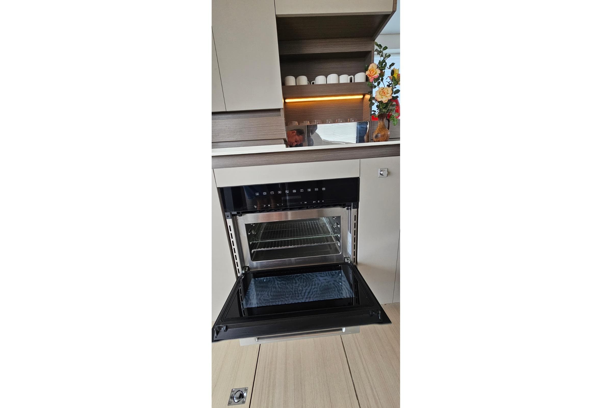 Modern kitchen interior on 2023 Leopard 40 Powercat with open oven and decorative elements.
