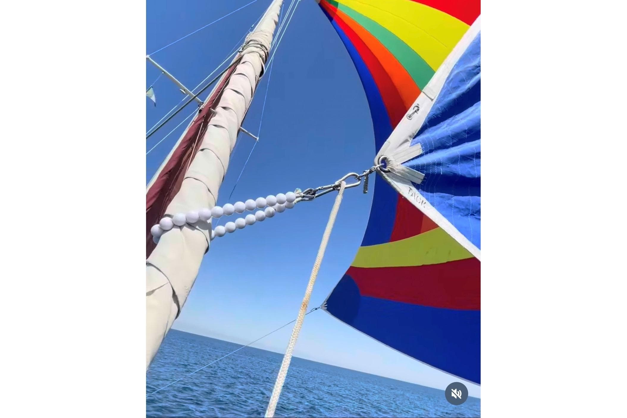 Colorful sails on a 1980 Hans Christian 43 sailboat against a clear blue sky.