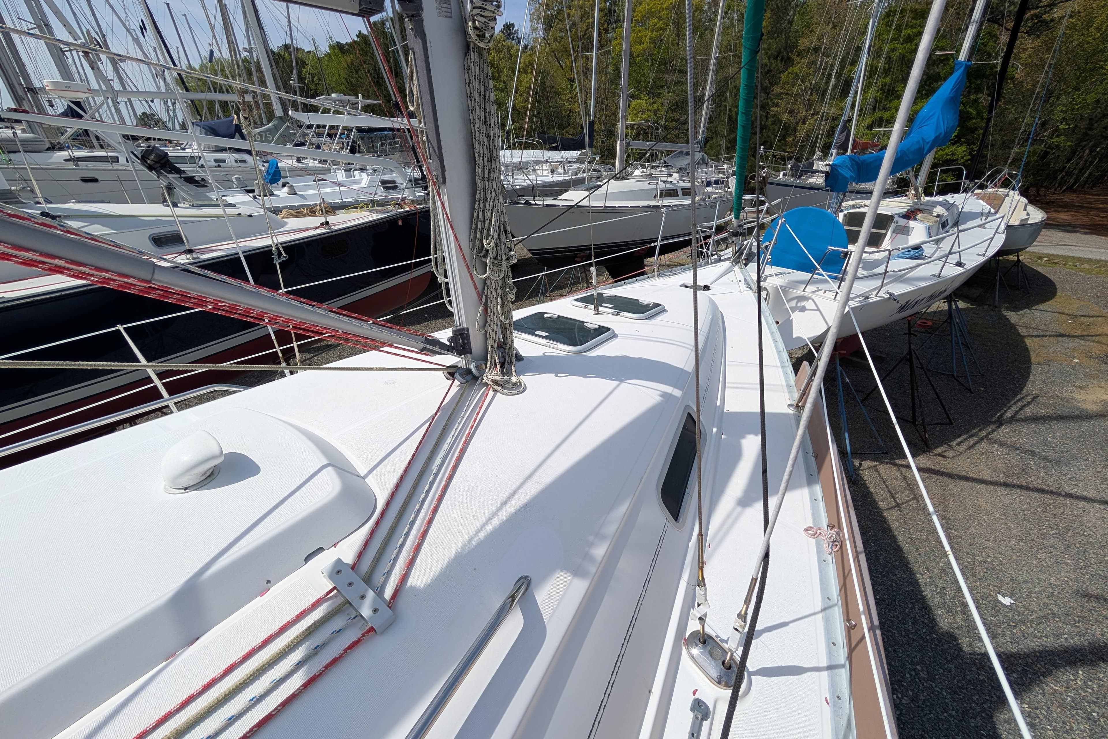 2003 Beneteau 331 sailboat on land, surrounded by other boats, mast and rigging visible.
