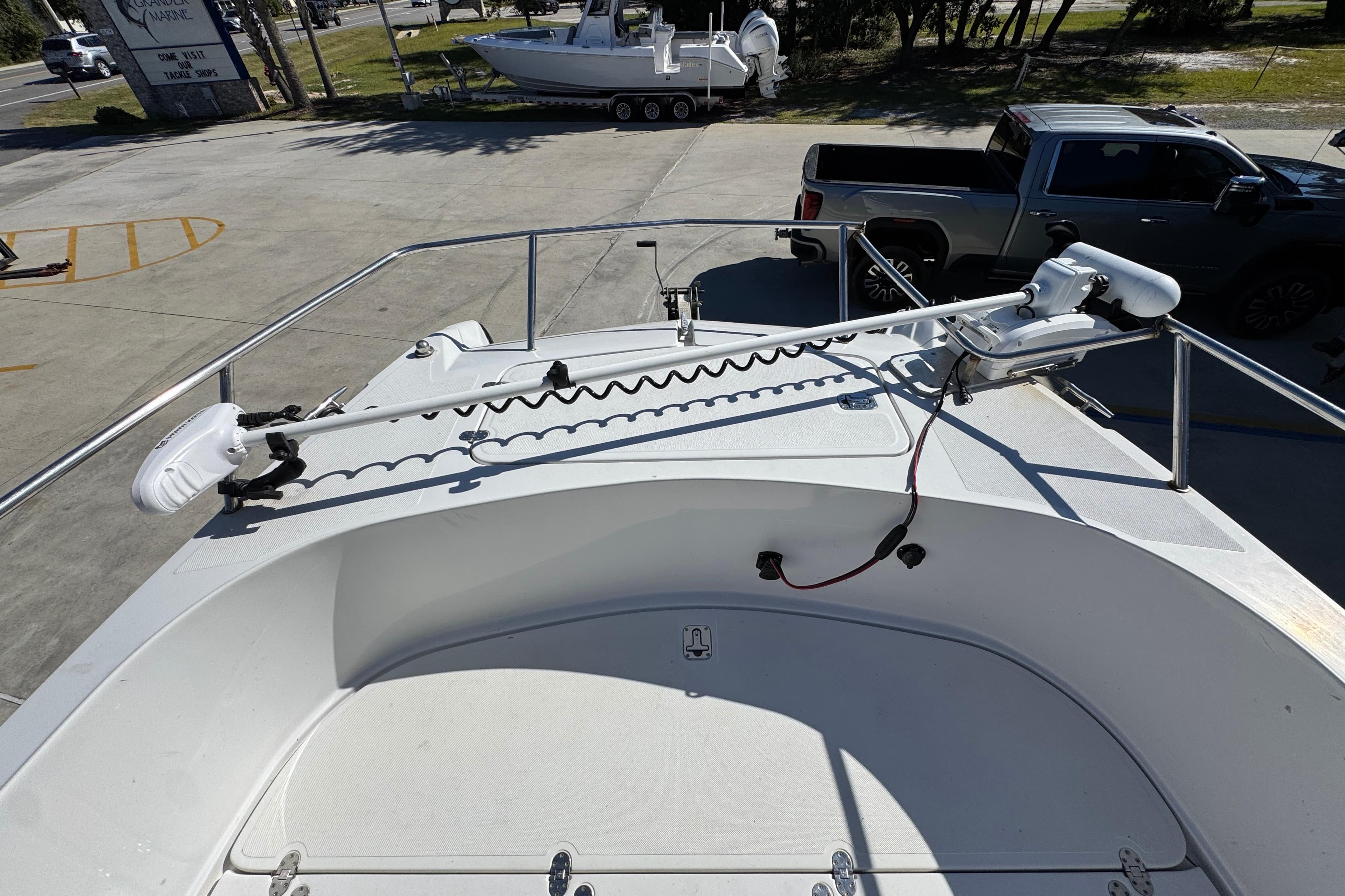 2005 Glacier Bay 260 Canyon Runner boat deck with trolling motor, parked in marina.