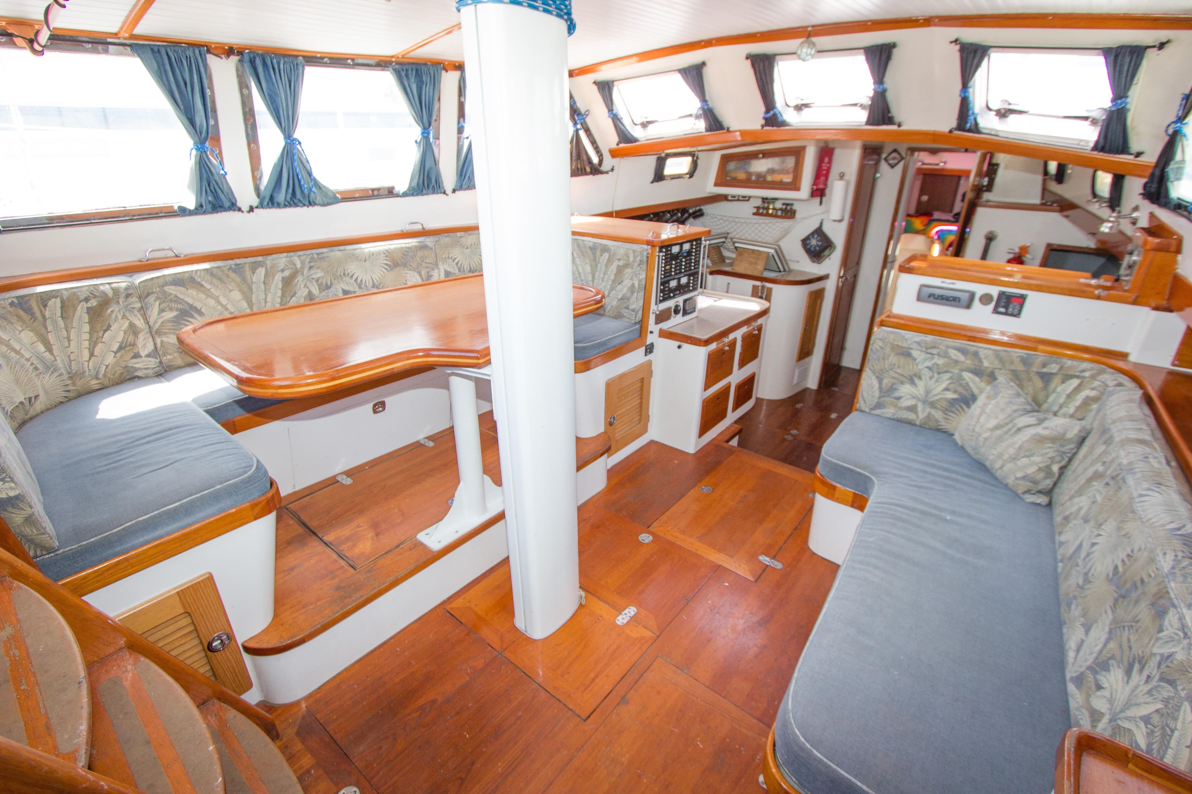 Interior of 1997 Crealock custom-built raised cabintop schooner with cozy seating and wooden finishes.