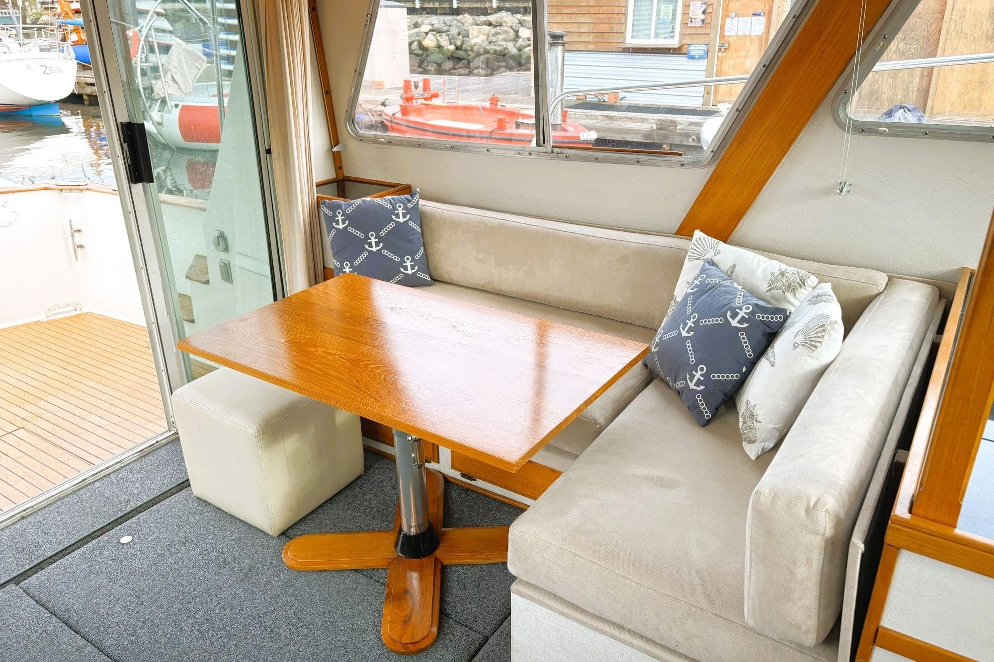 1980 Tollycraft 34 Sedan interior with cozy seating and nautical-themed cushions.