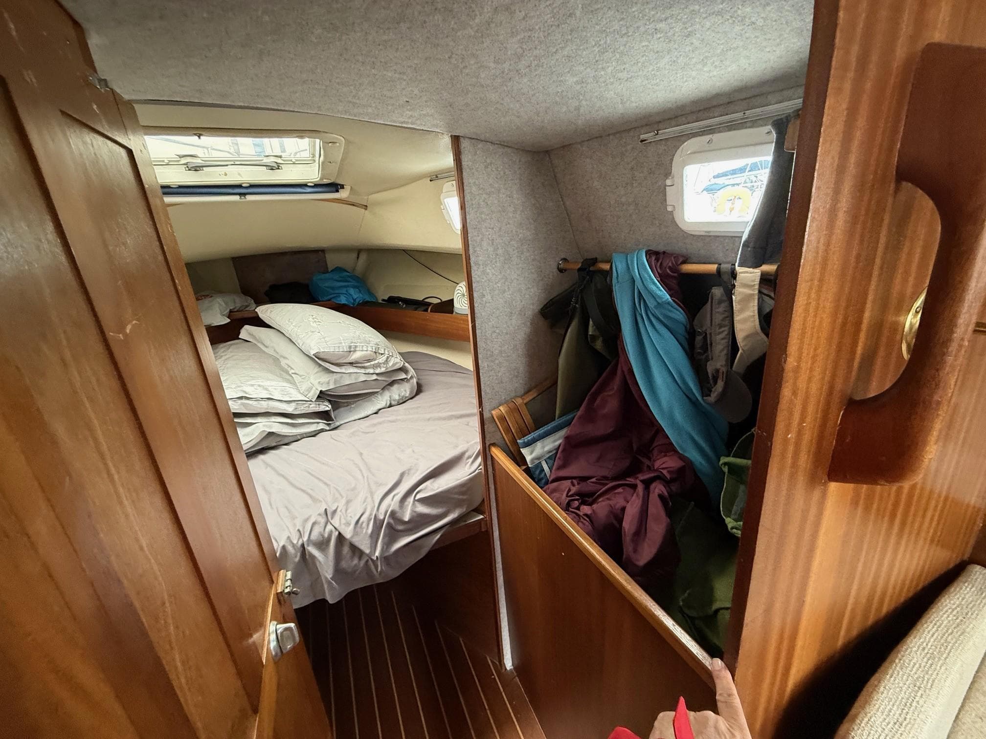 Cozy cabin interior of 1980 Westerly Konsort sailboat with bed and storage area.