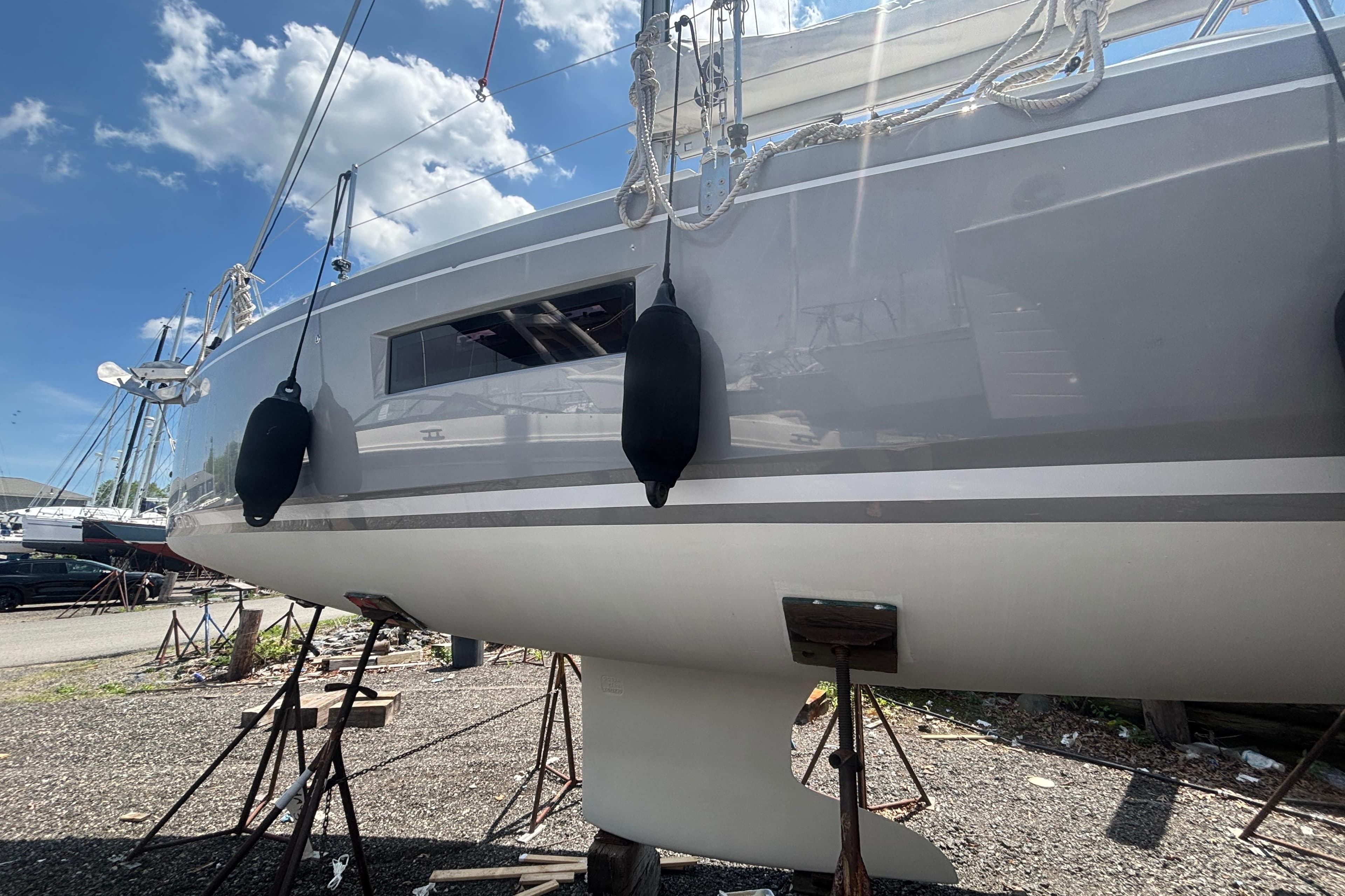 2021 Beneteau Oceanis 30.1 sailboat on stands, under a clear blue sky.