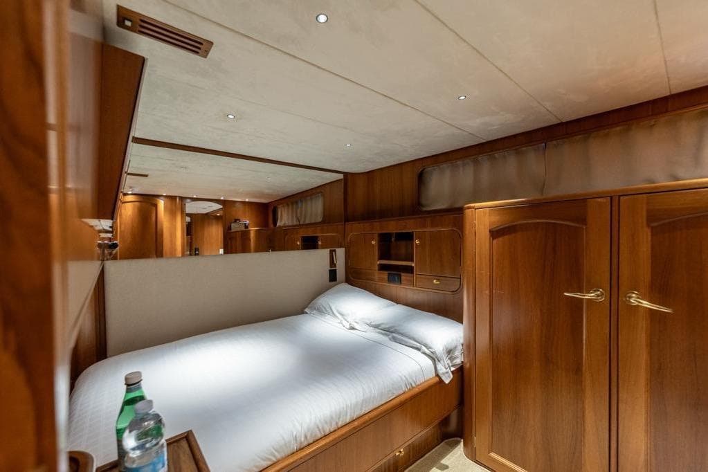 Luxurious cabin interior of 1986 Moonen 85 yacht with wooden furnishings and cozy bed.