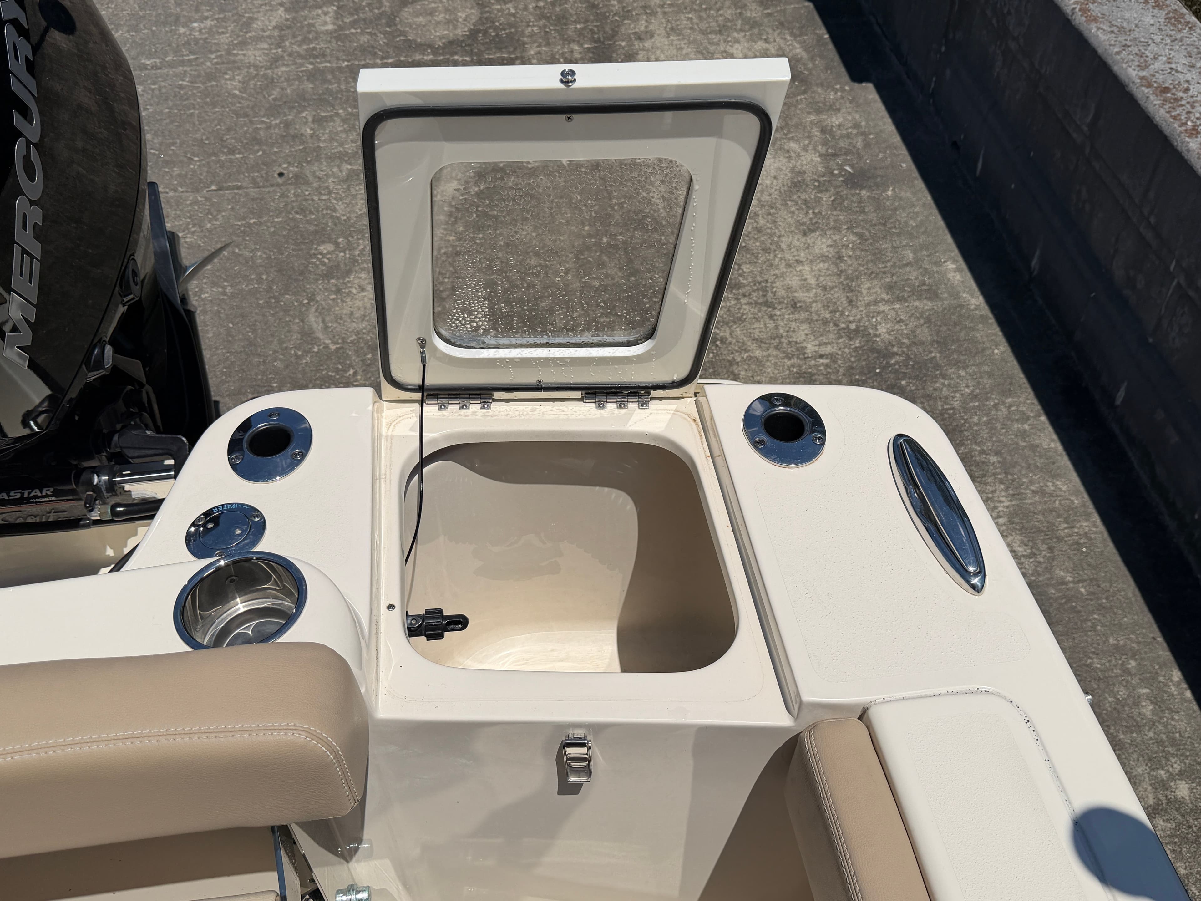 2024 Scout 215 Dorado boat with open storage compartment lid.