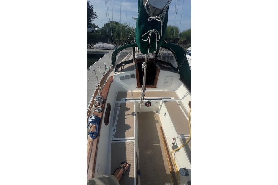 1980 Shannon 28 sailboat cockpit with green canopy and wooden trim.