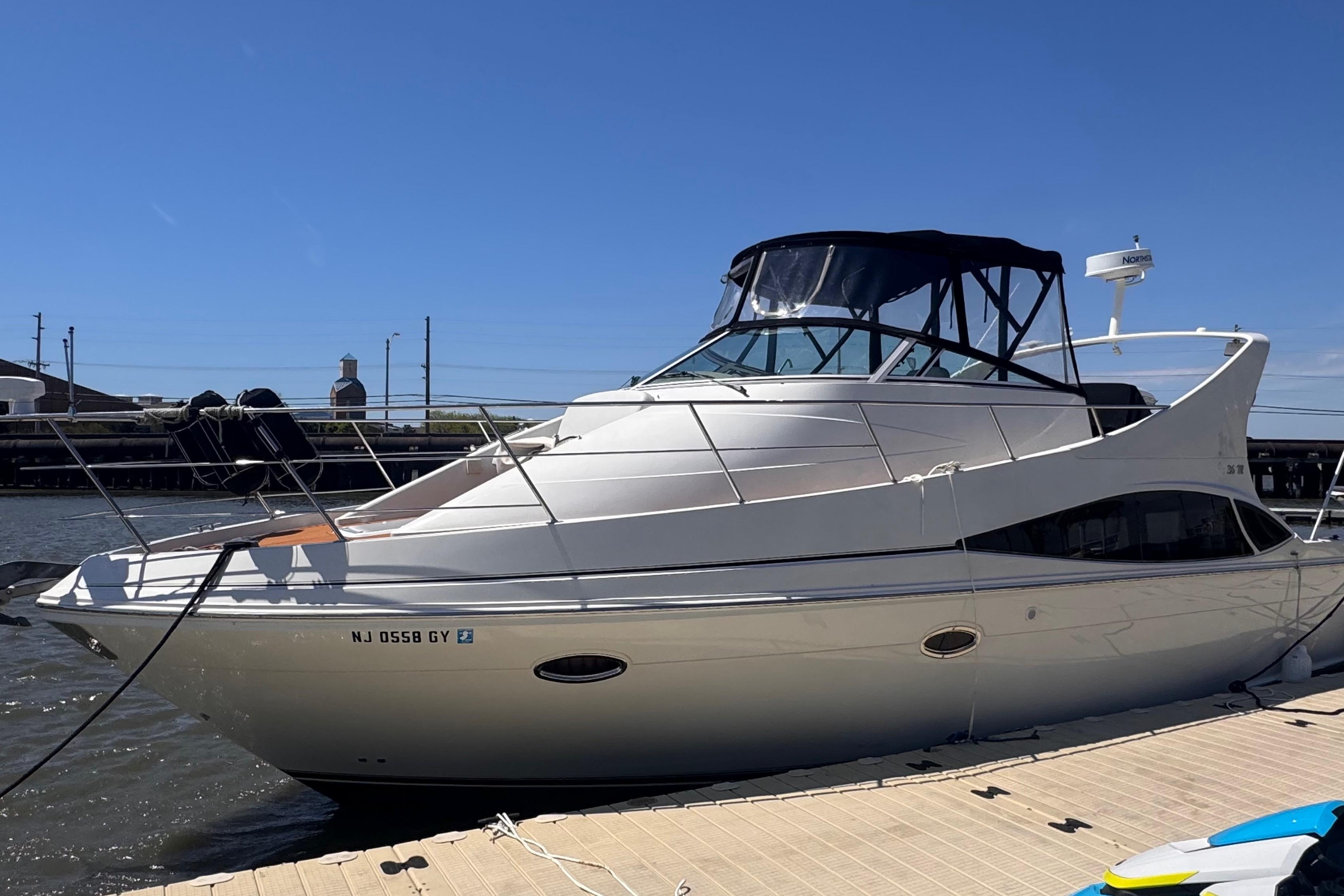 2006 Carver 36 Mariner yacht docked at marina under clear blue sky.