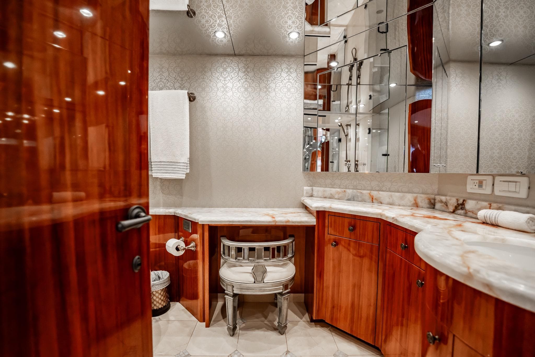 Luxurious bathroom on 2012 Hatteras 80 Motor Yacht with elegant wood cabinetry and marble countertops.