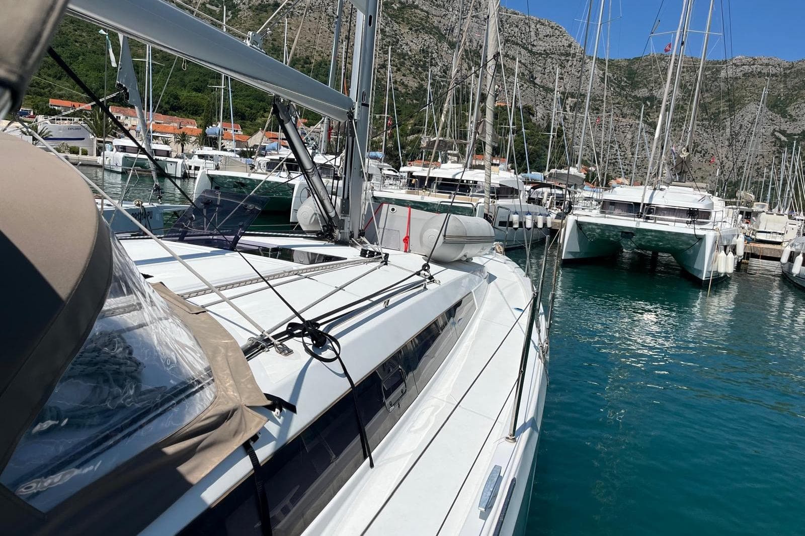 2022 Jeanneau Sun Odyssey 410 yacht docked in a marina with surrounding sailboats.