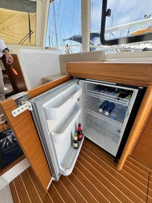 Open fridge on 2022 Rodman 1290 Evolution yacht, stocked with drinks.