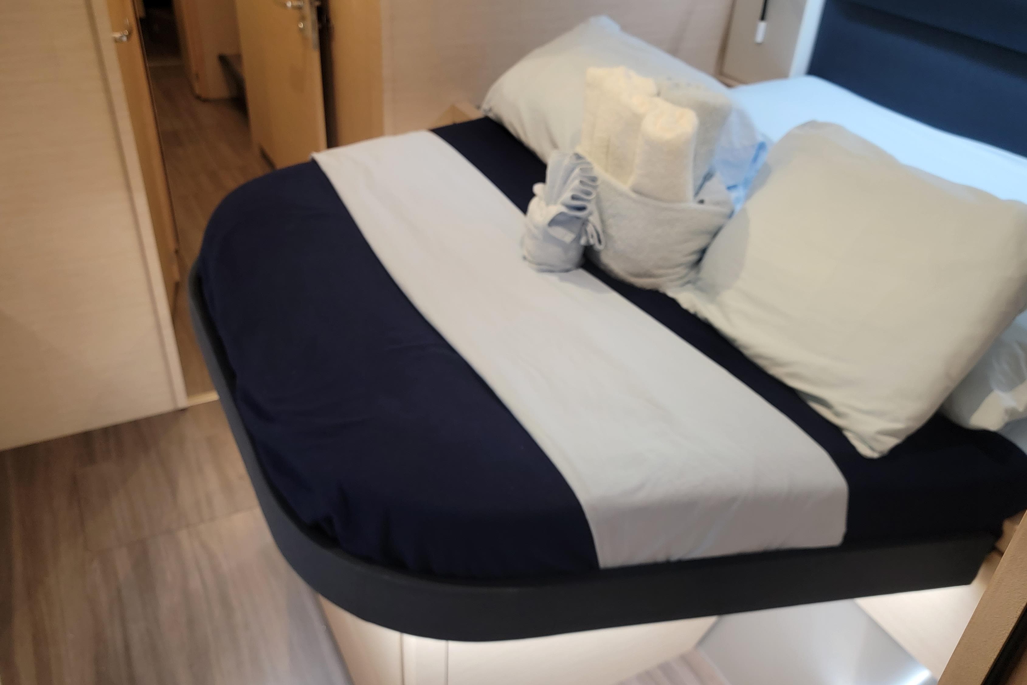 Cozy bedroom interior of 2019 Fountaine Pajot Saona 47 catamaran with neatly arranged bed linens.