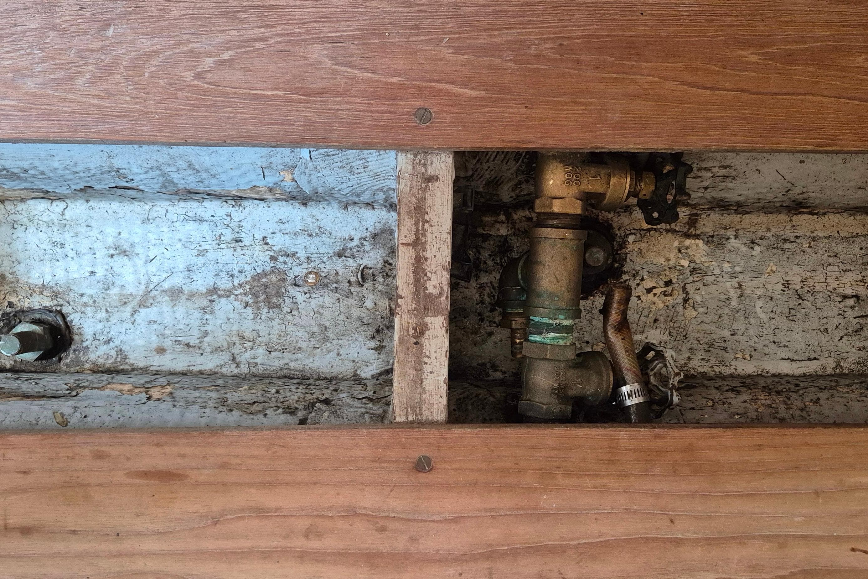 Bilge area of 1996 Morris Yachts Frances, showing plumbing and wooden flooring.