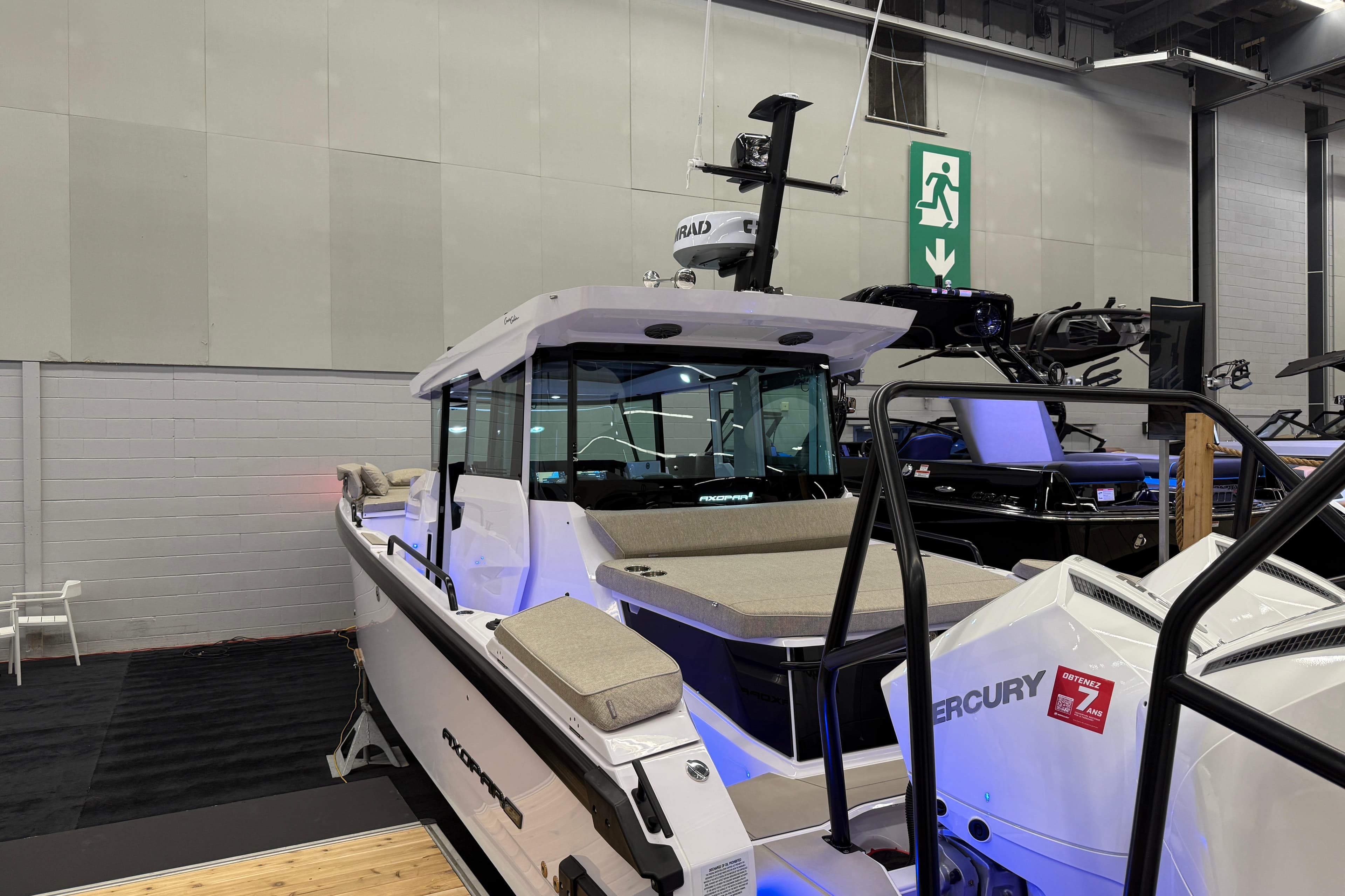 2026 Axopar 29 XC Cross Cabin boat displayed indoors with Mercury engine.