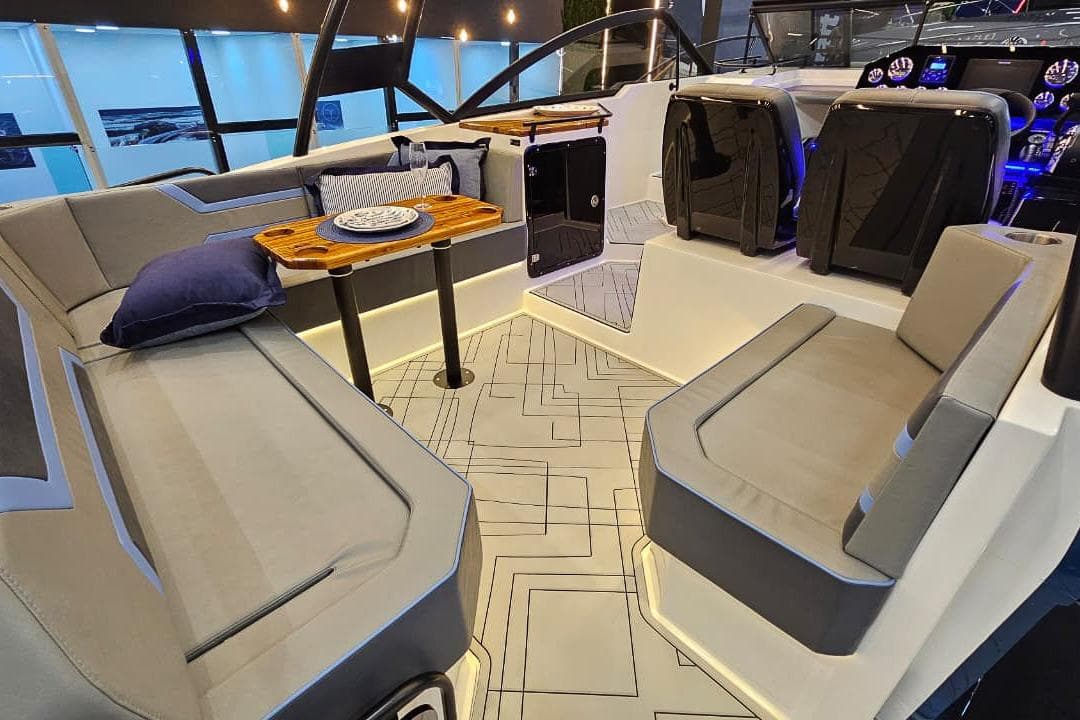 Luxurious interior of 2026 Hanover 327 boat with modern seating and elegant table setup.