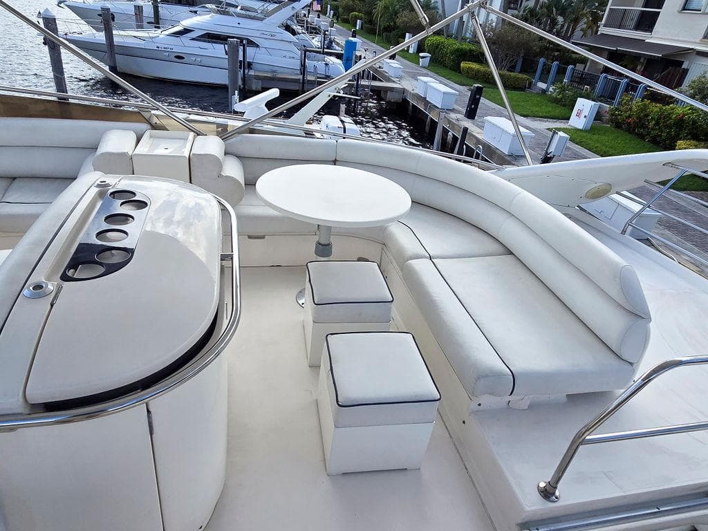 1998 Viking Princess 56 Sport Cruiser with elegant white seating and outdoor dining area.