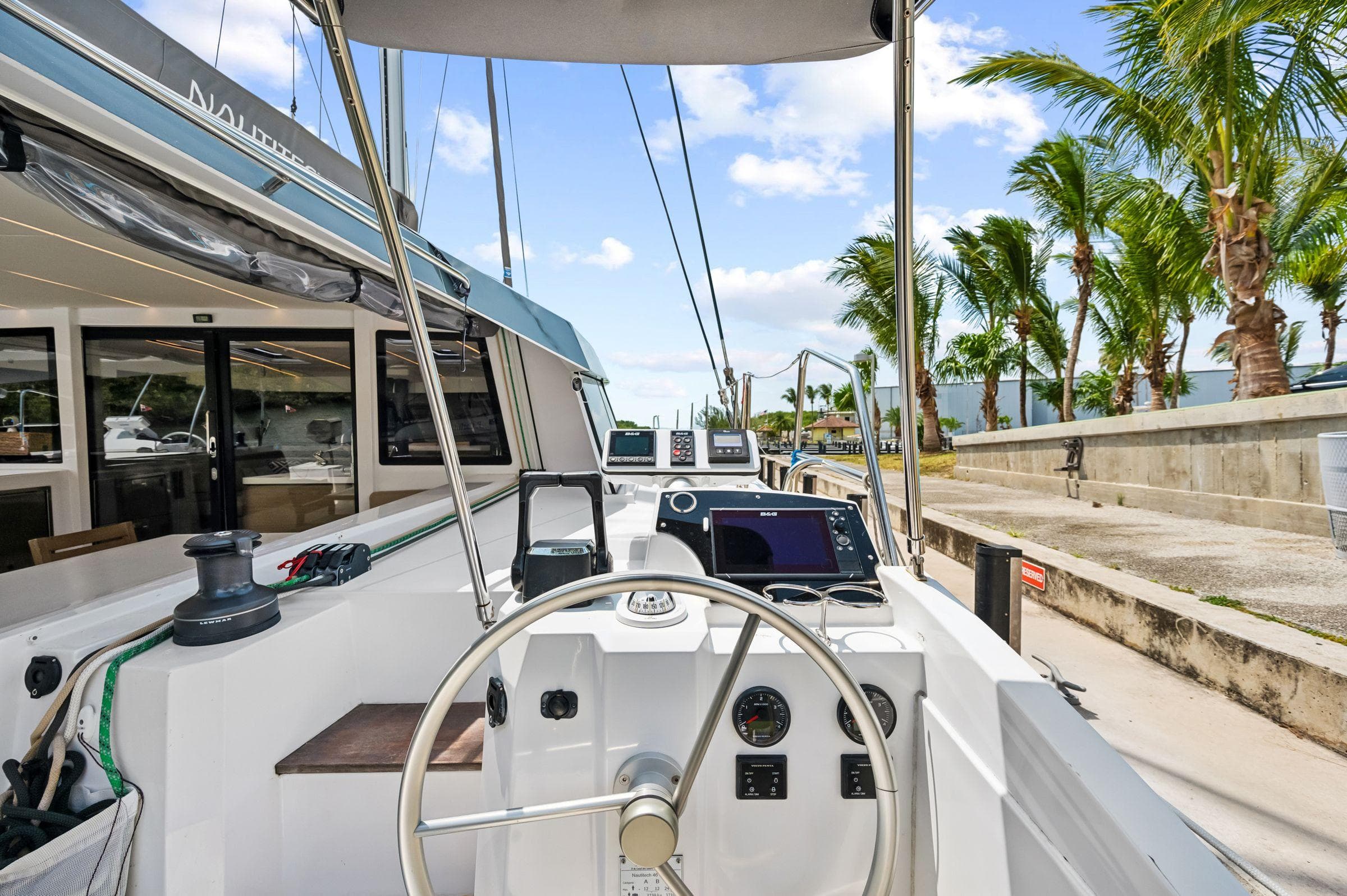 Nautitech 46 Open 2021 catamaran helm with tropical backdrop and clear skies.