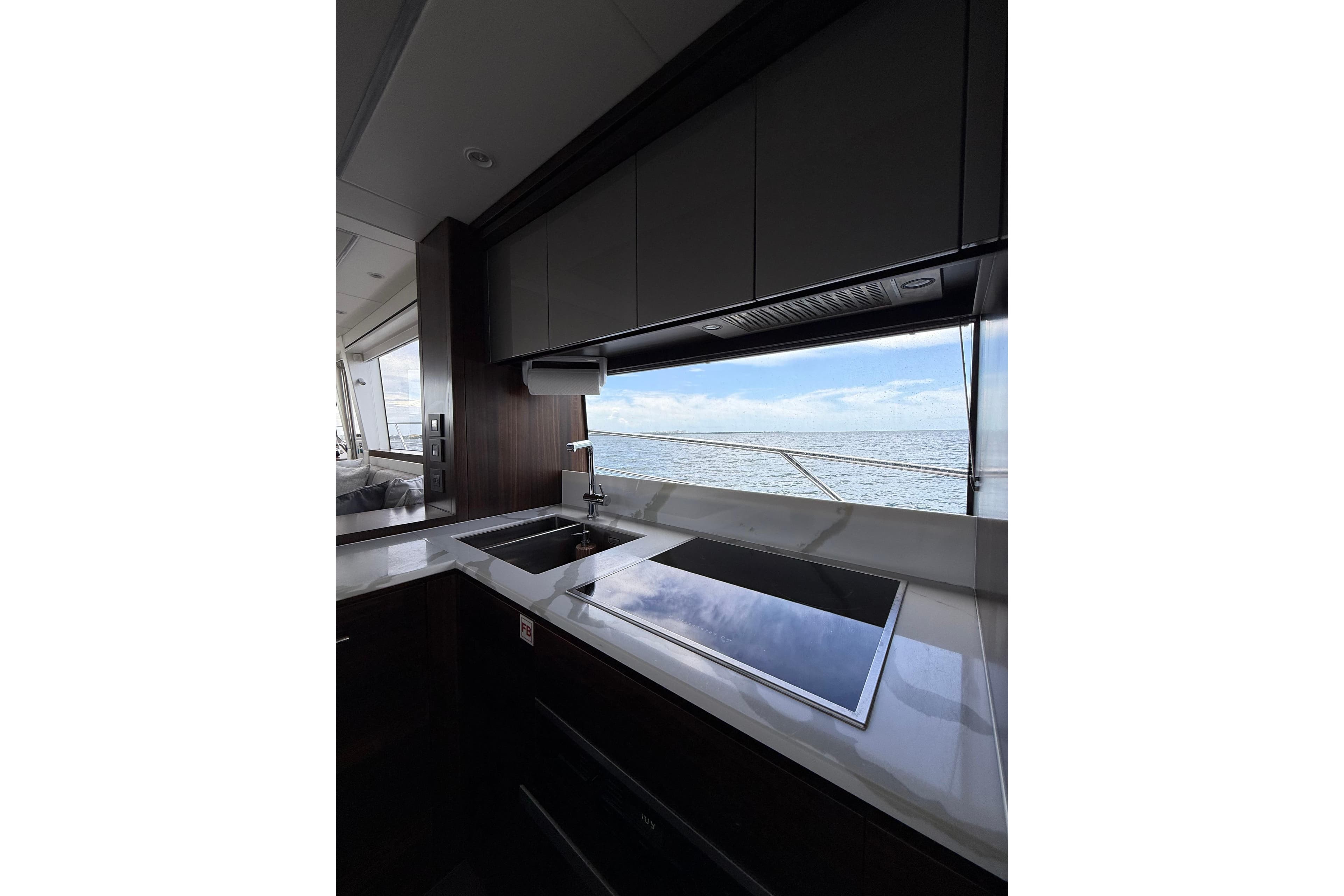 Modern kitchen interior of 2022 Sunseeker Manhattan 68 yacht with ocean view.