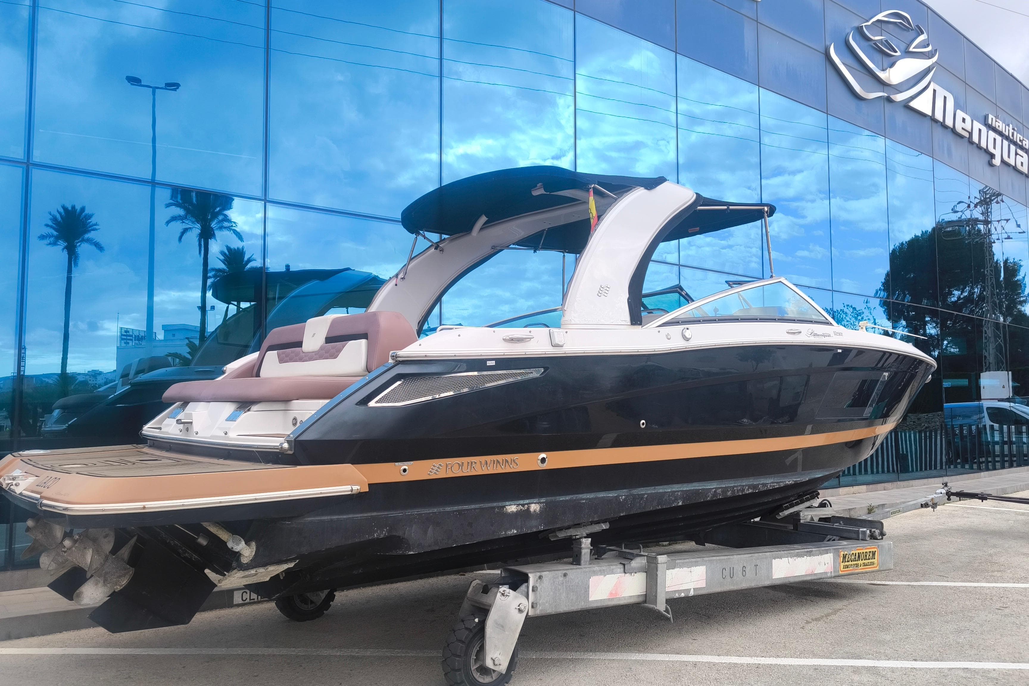 2017 Four Winns H290 boat on trailer outside a glass building.