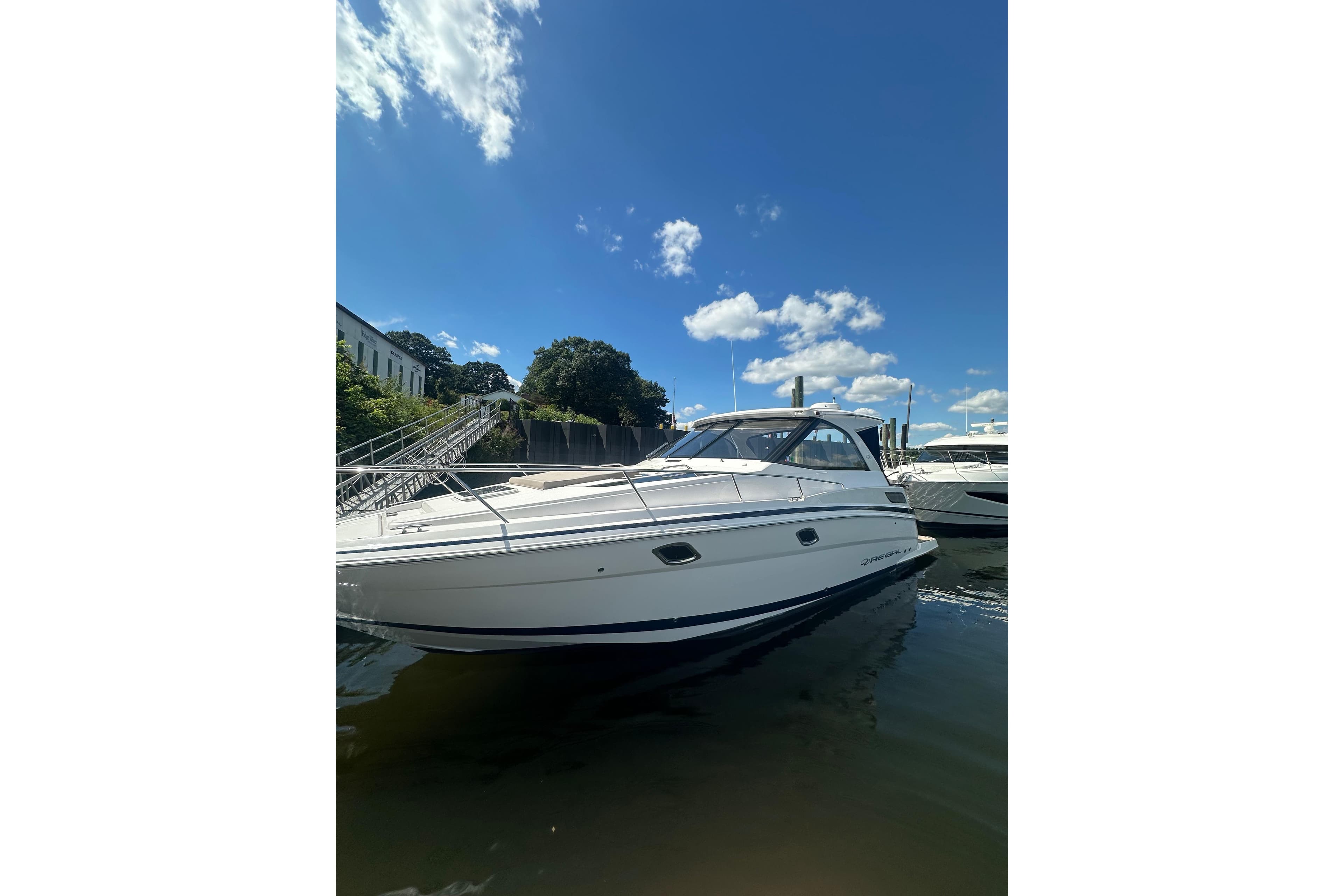 2014 Regal 35 Sport Coupe boat docked under a clear blue sky.
