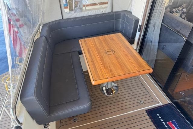 Luxurious seating area on 2022 Nimbus 365 Coupe yacht with wooden table.