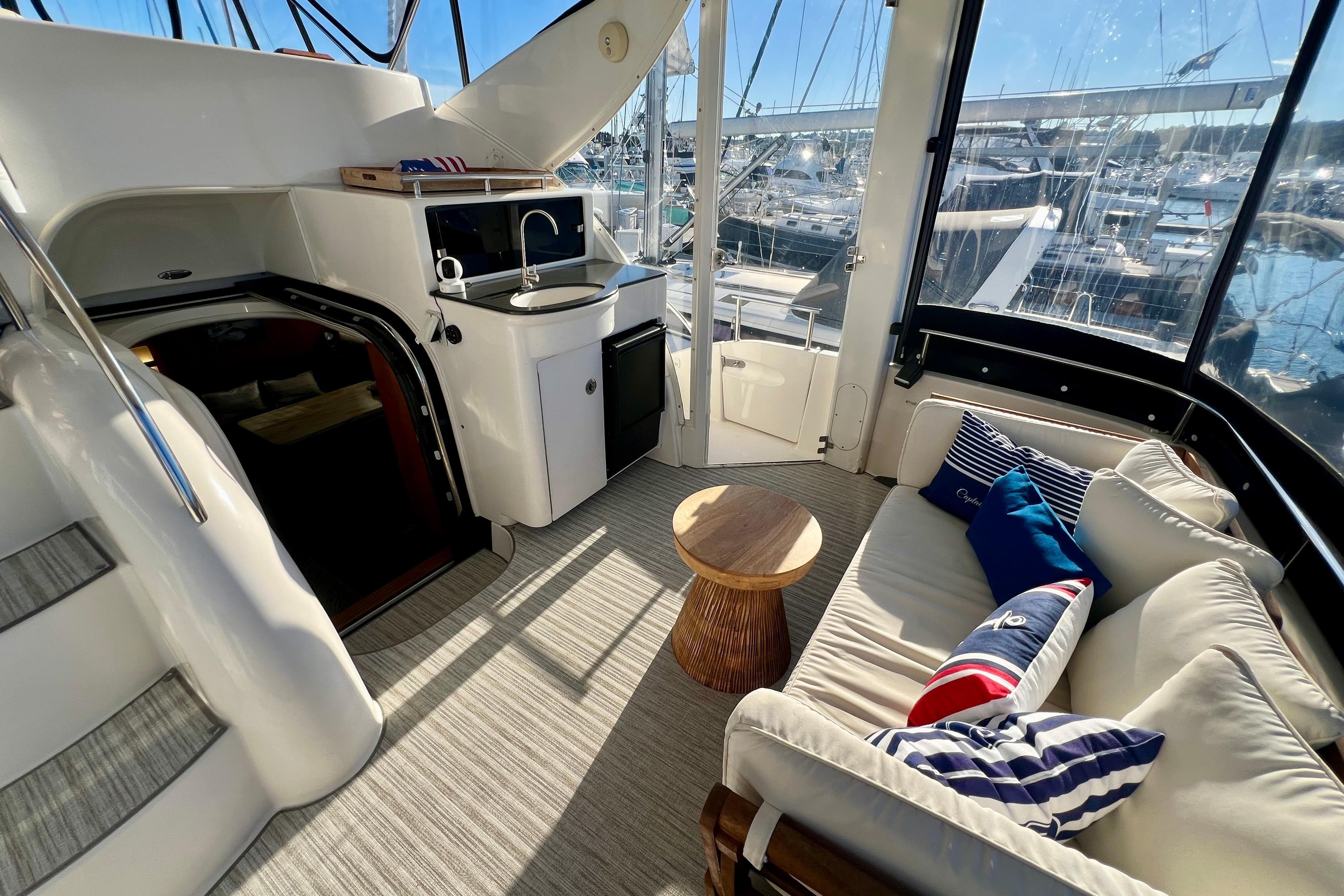 Luxurious 2004 Meridian 408 Motoryacht interior with seating, kitchenette, and marina view.