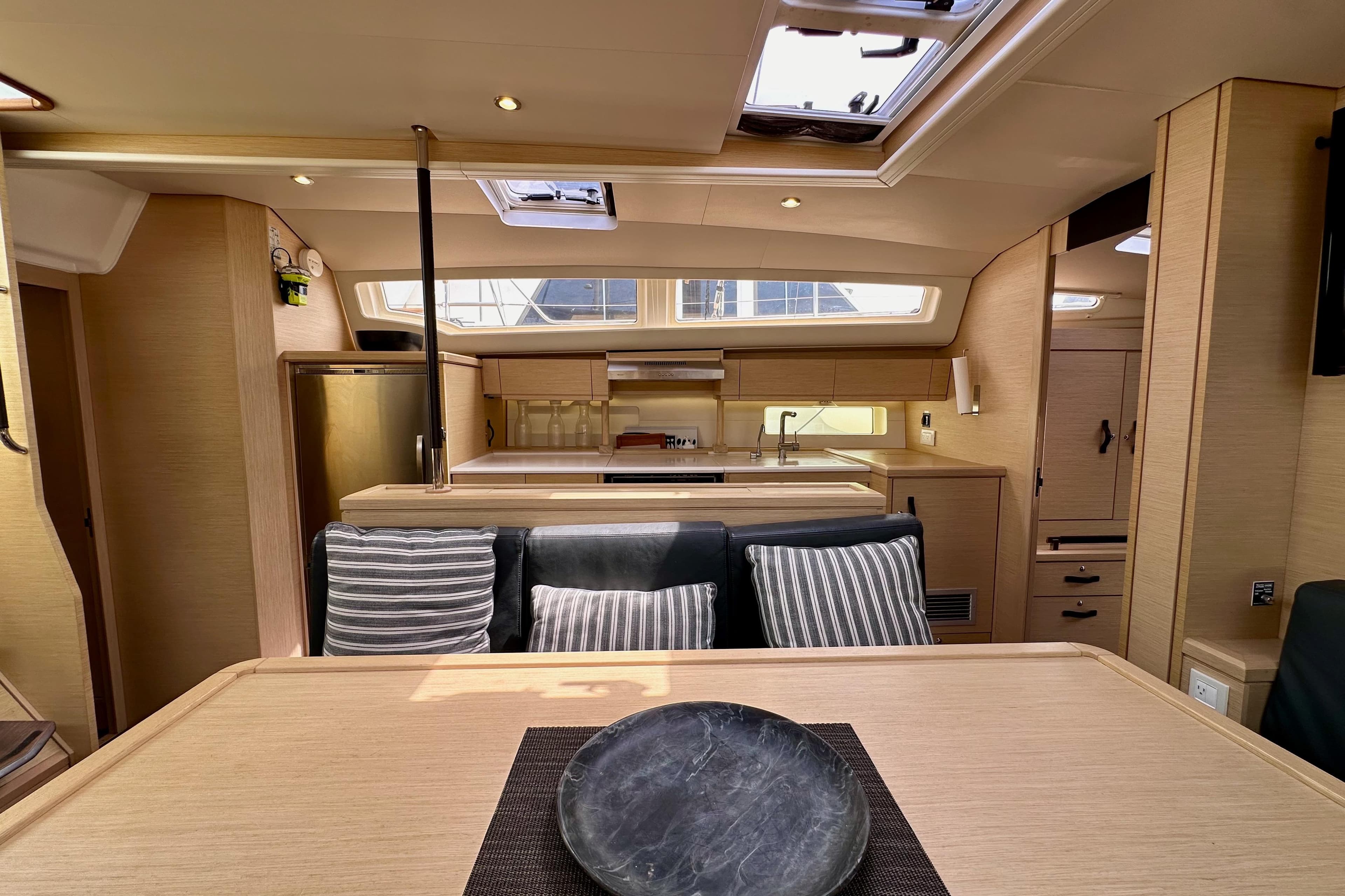 Luxurious interior of 2018 Jeanneau 54 yacht with modern kitchen and dining area.
