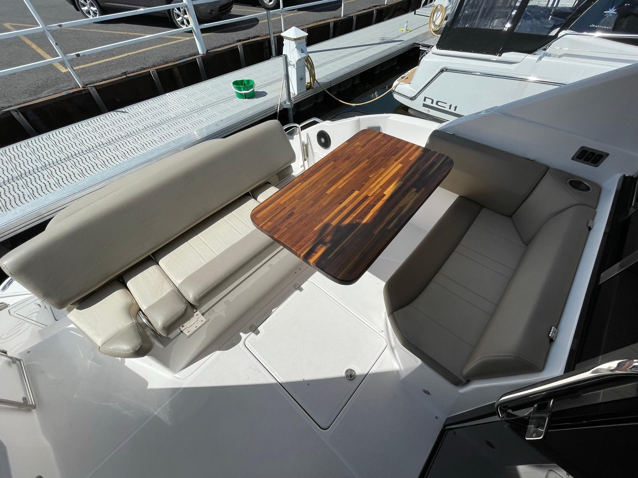 2015 Regal 42 Sport Coupe boat with cushioned seating and wooden table on deck.