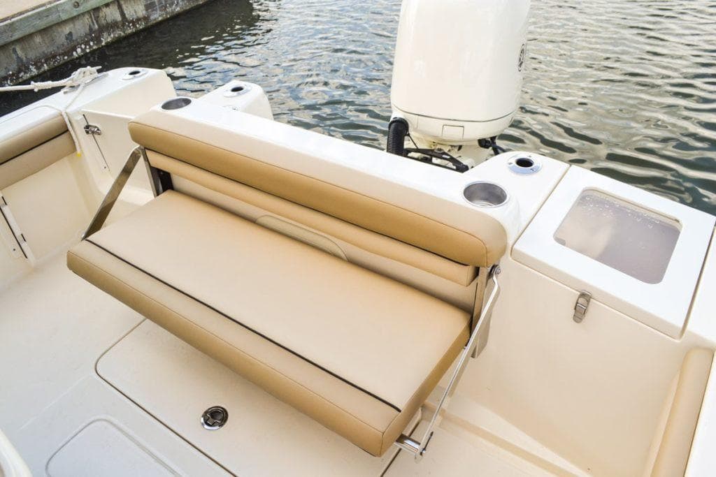 Manufacturer Provided Image: 2025 Scout 215 XSF boat with tan seating and outboard motor by the water.