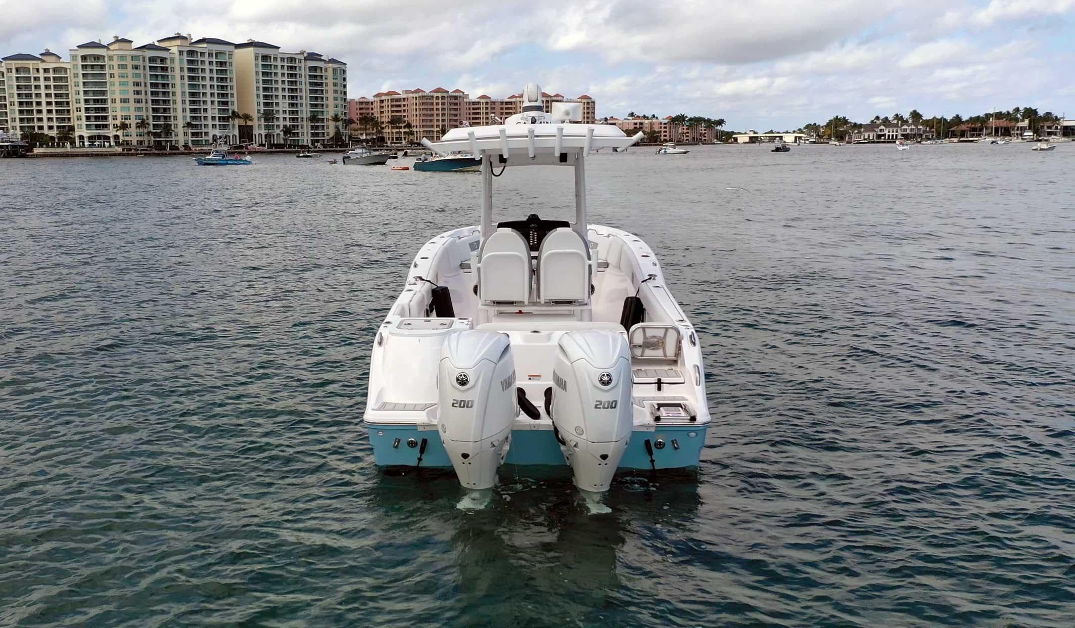 2024 Sea Fox 268 Commander boat on water with twin engines, coastal buildings in background.