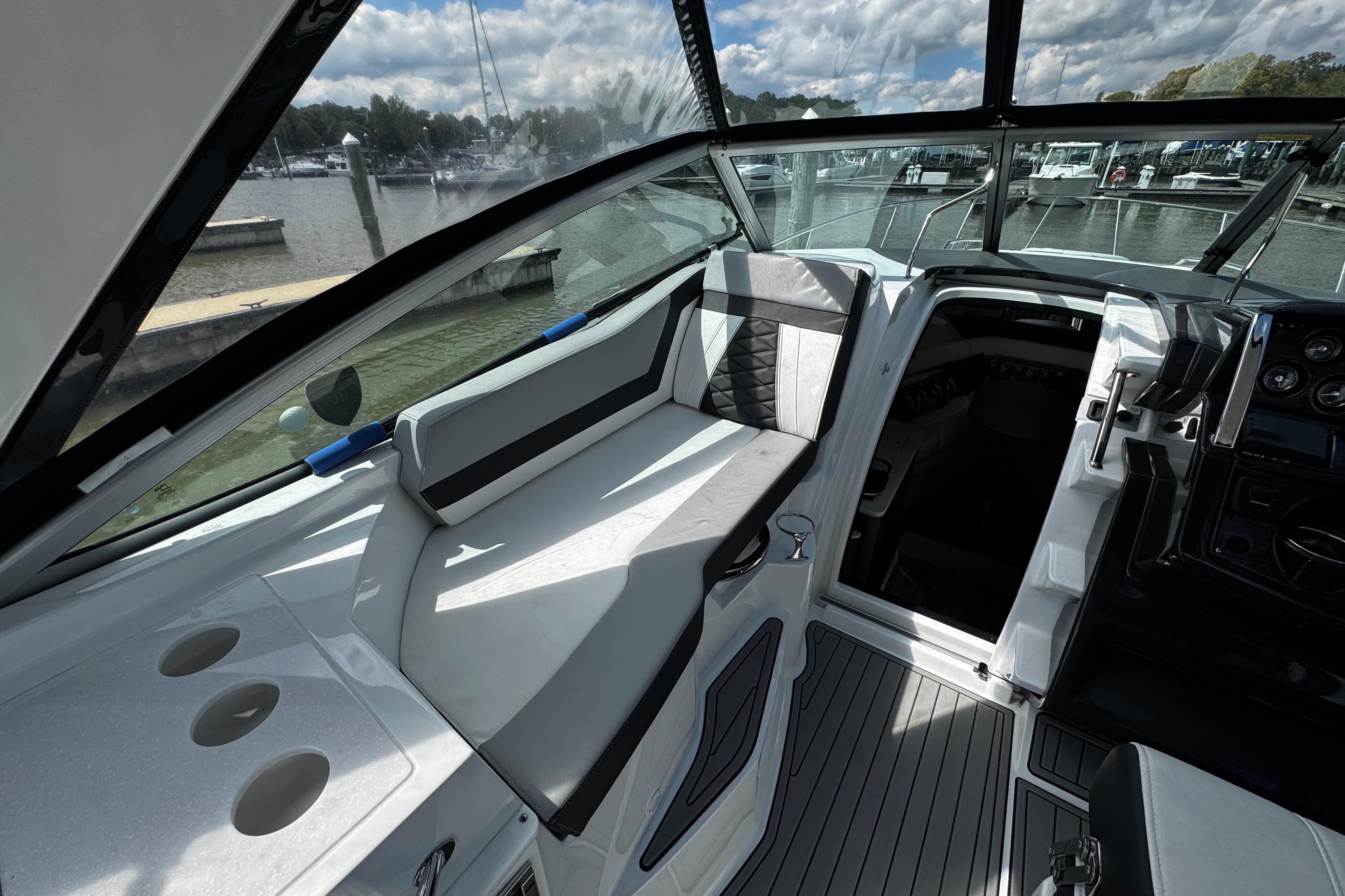2022 Monterey 295 Sport Yacht interior with sleek seating and modern dashboard at marina.