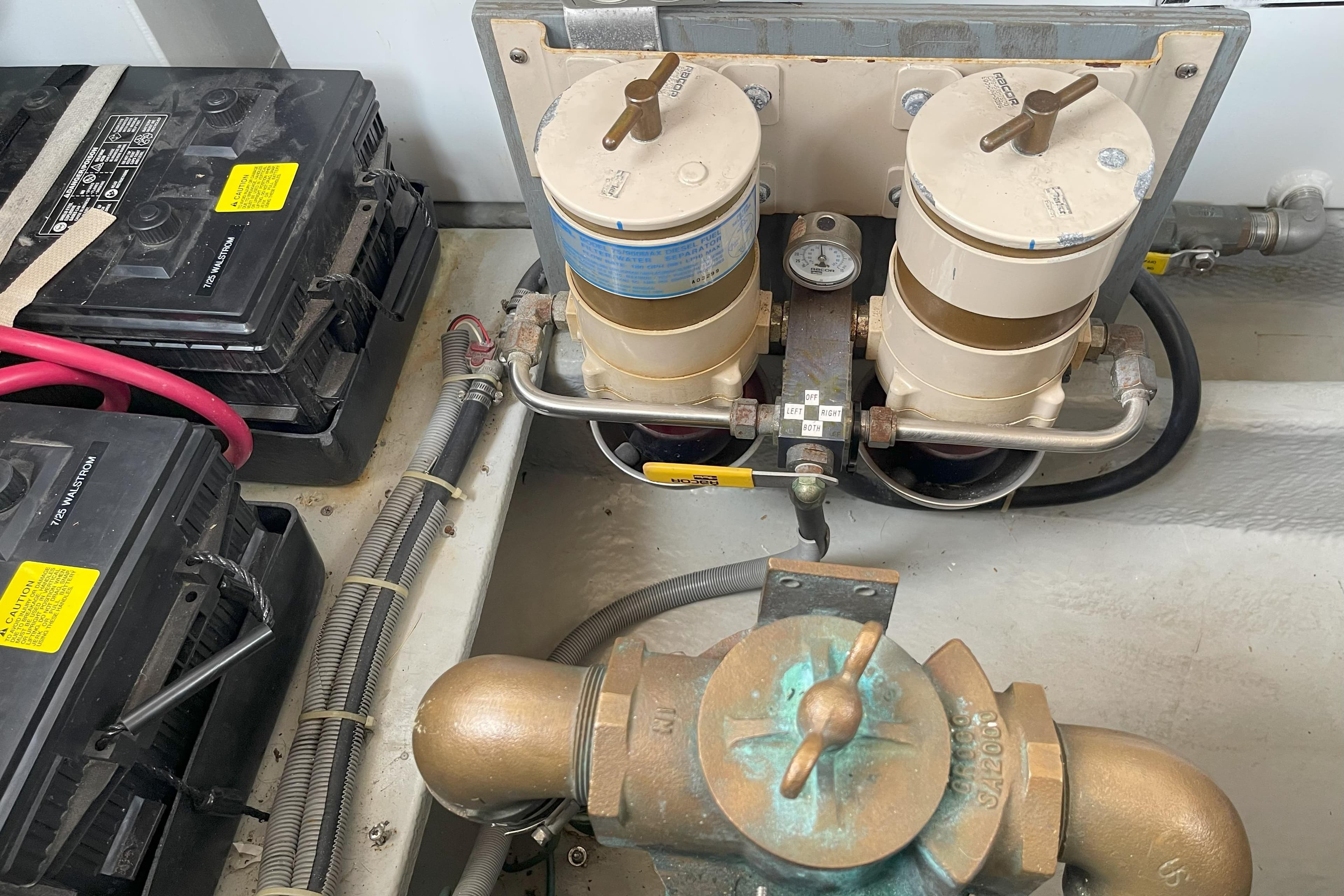 Engine room of 2000 Mainship 390 Trawler with batteries and fuel filters.