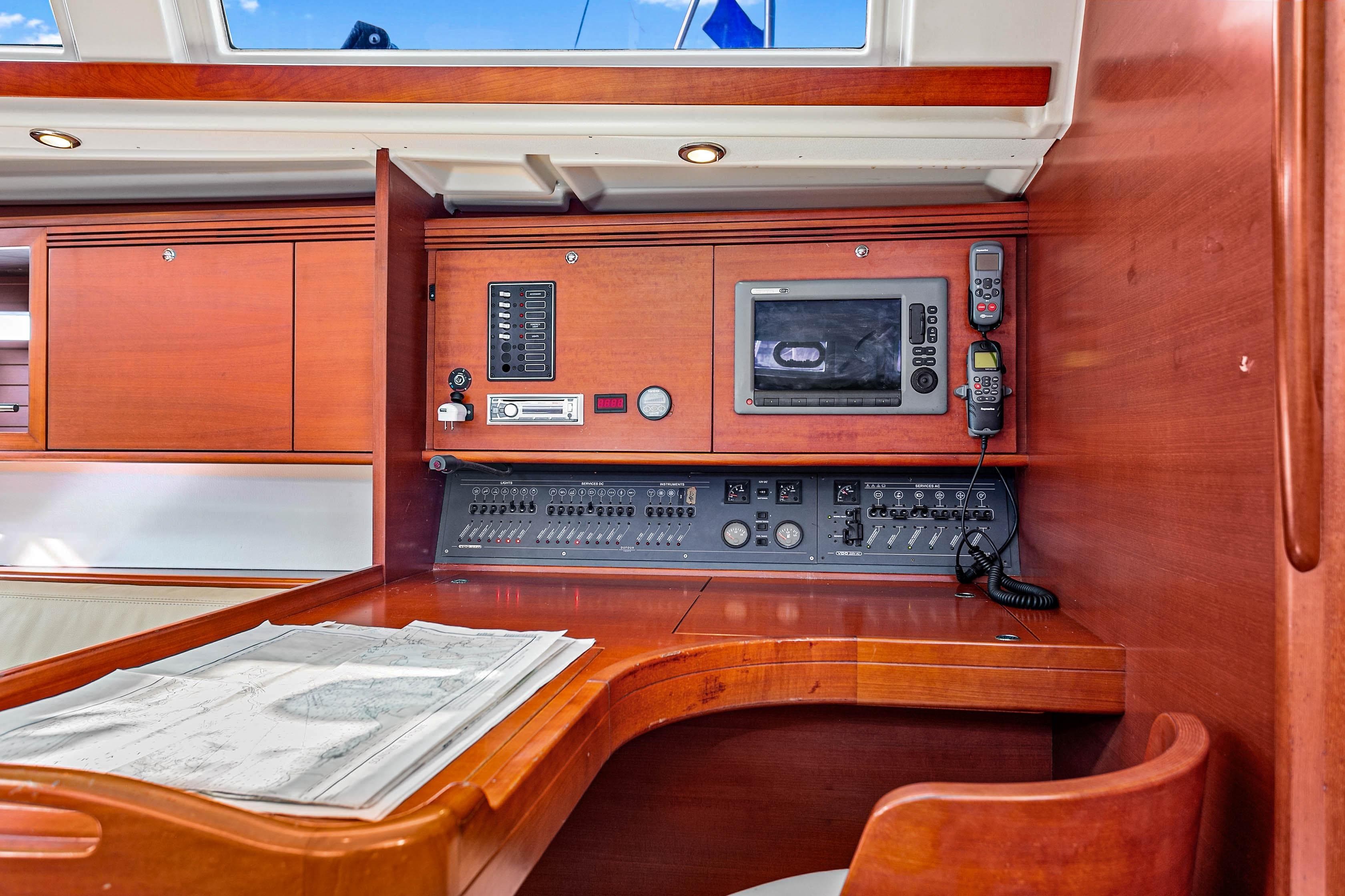 Navigation station on 2011 Dufour 525 Grand Large yacht with control panel and chart.