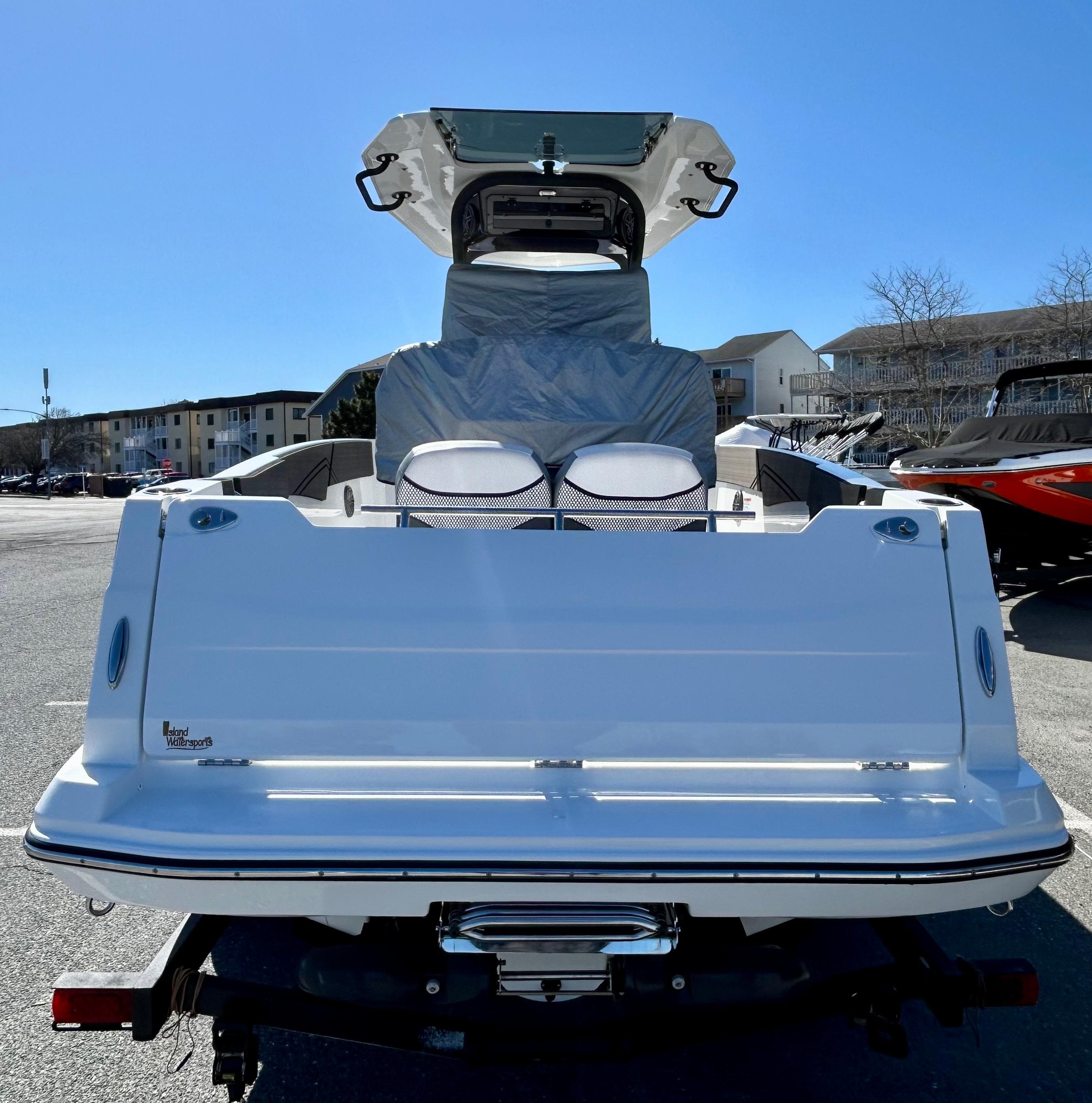 2024 Scarab 255 Open boat, rear view, parked outdoors under clear blue sky.