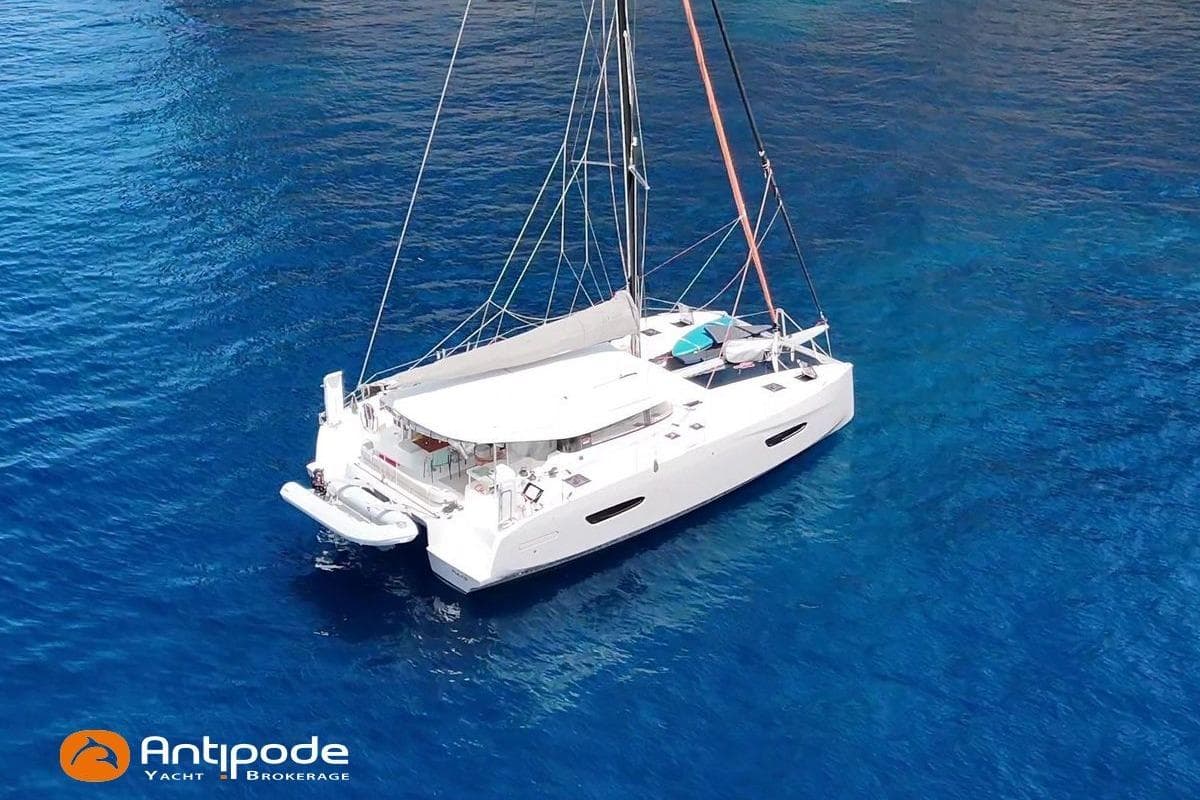 2023 Excess 14 catamaran sailing on clear blue water, viewed from above.