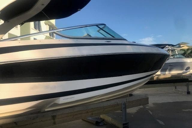 2012 Regal 2500 Bowrider boat on display, featuring sleek black and white design.