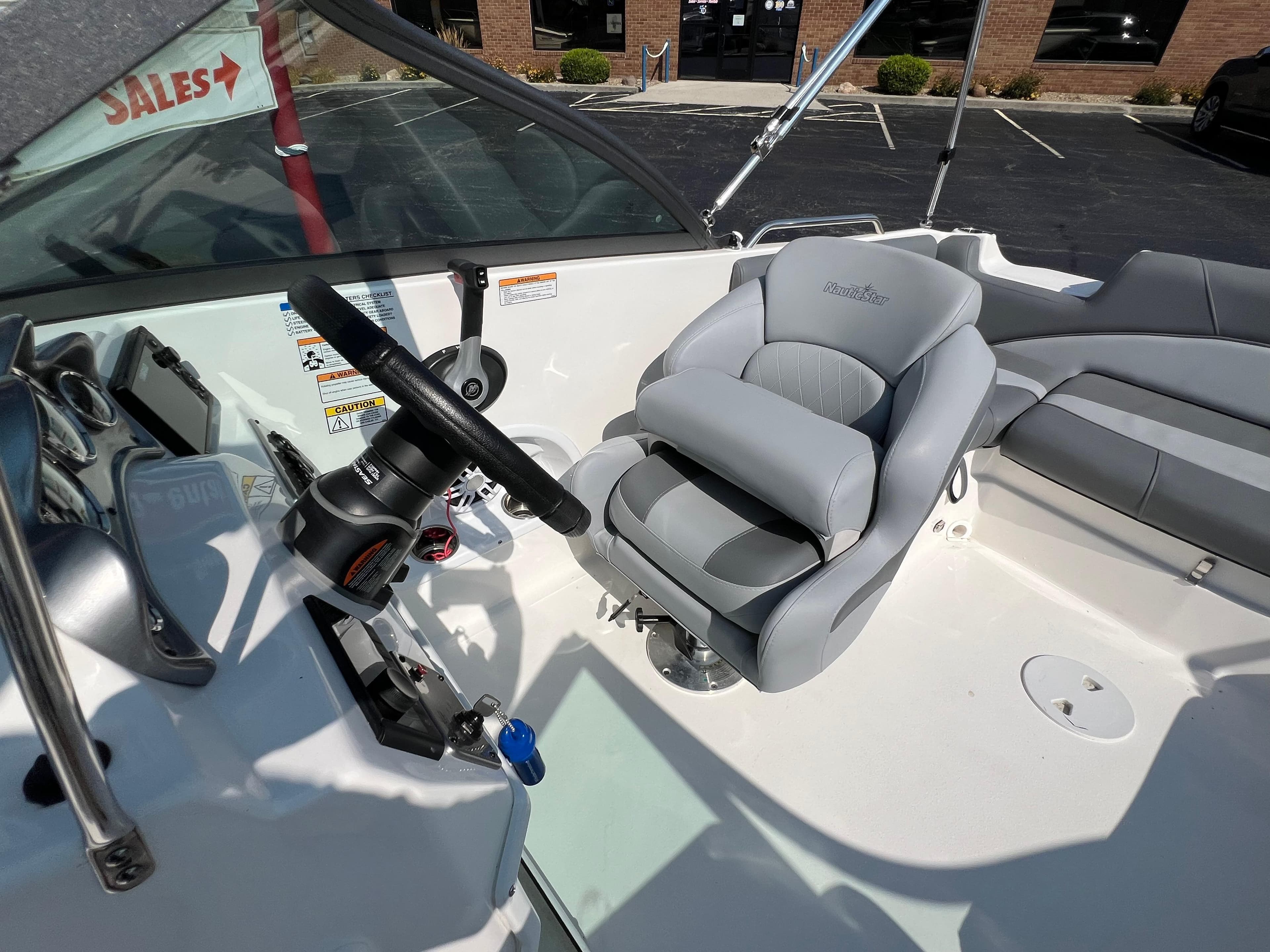 2023 NauticStar 203 DC boat interior with steering wheel and comfortable seating.
