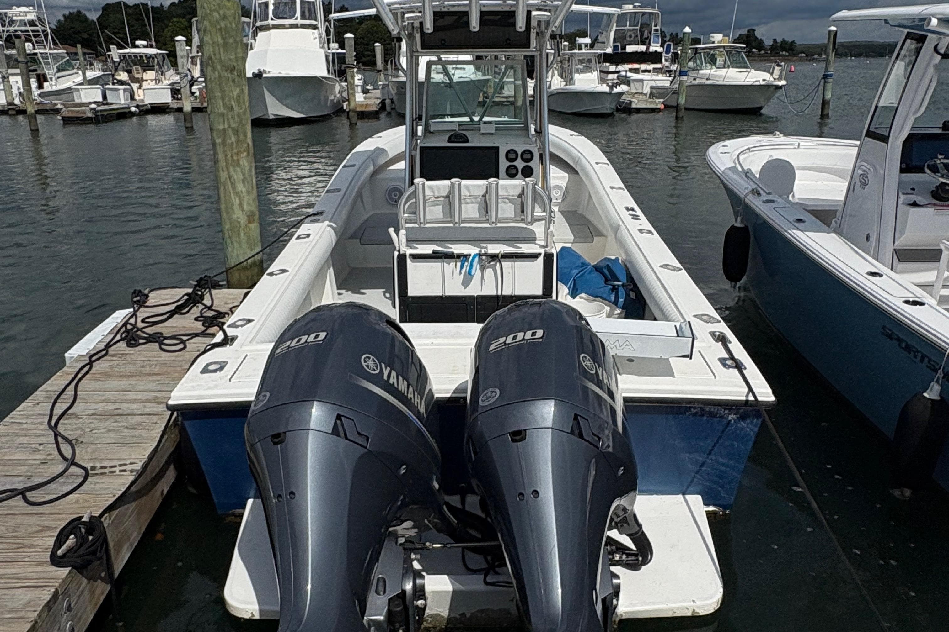 2000 Regulator 26 Center Console boat with twin Yamaha 200 engines docked at marina.