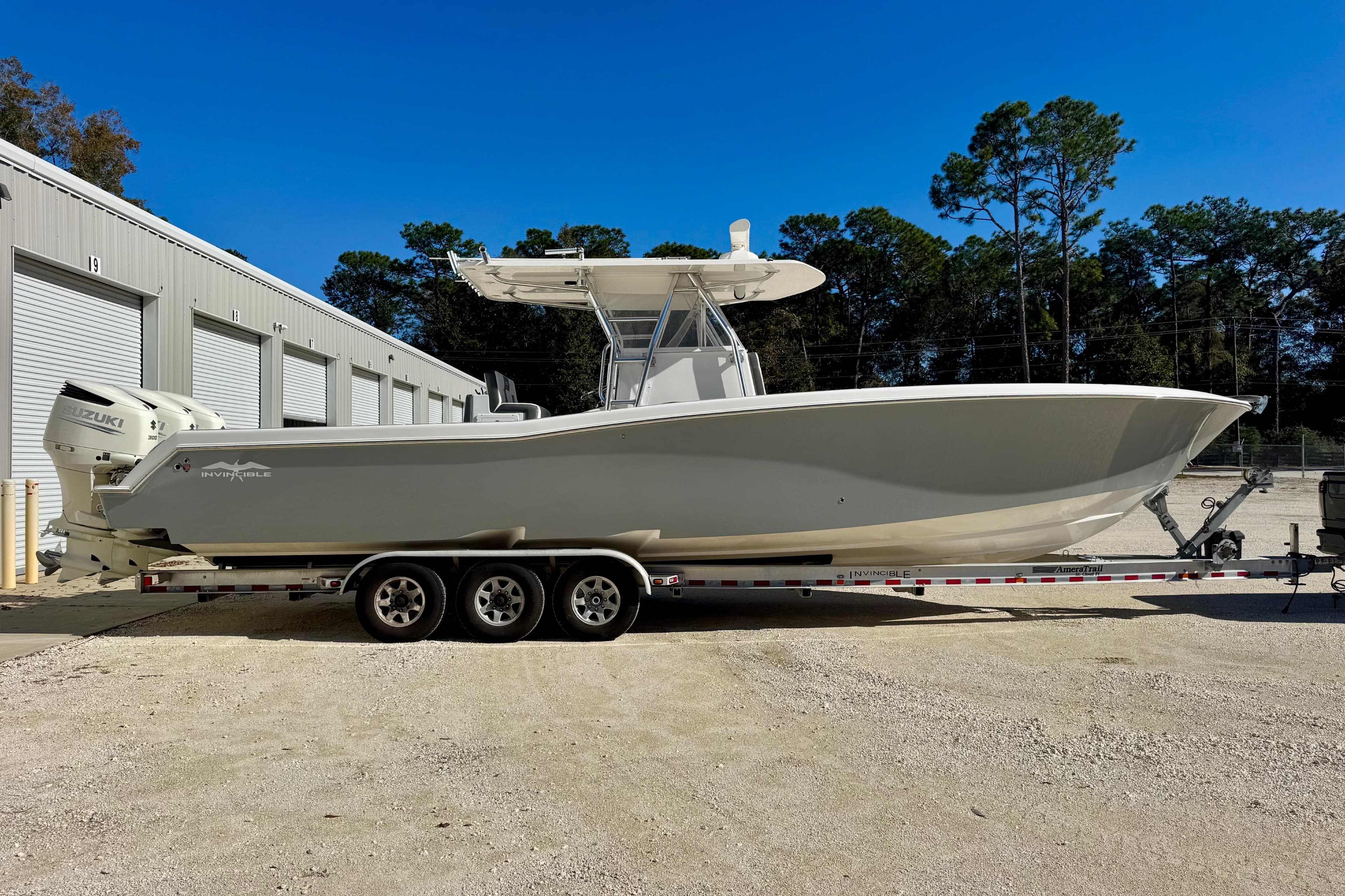 2014 Invincible 36 Open Fisherman boat on trailer, parked near storage units.