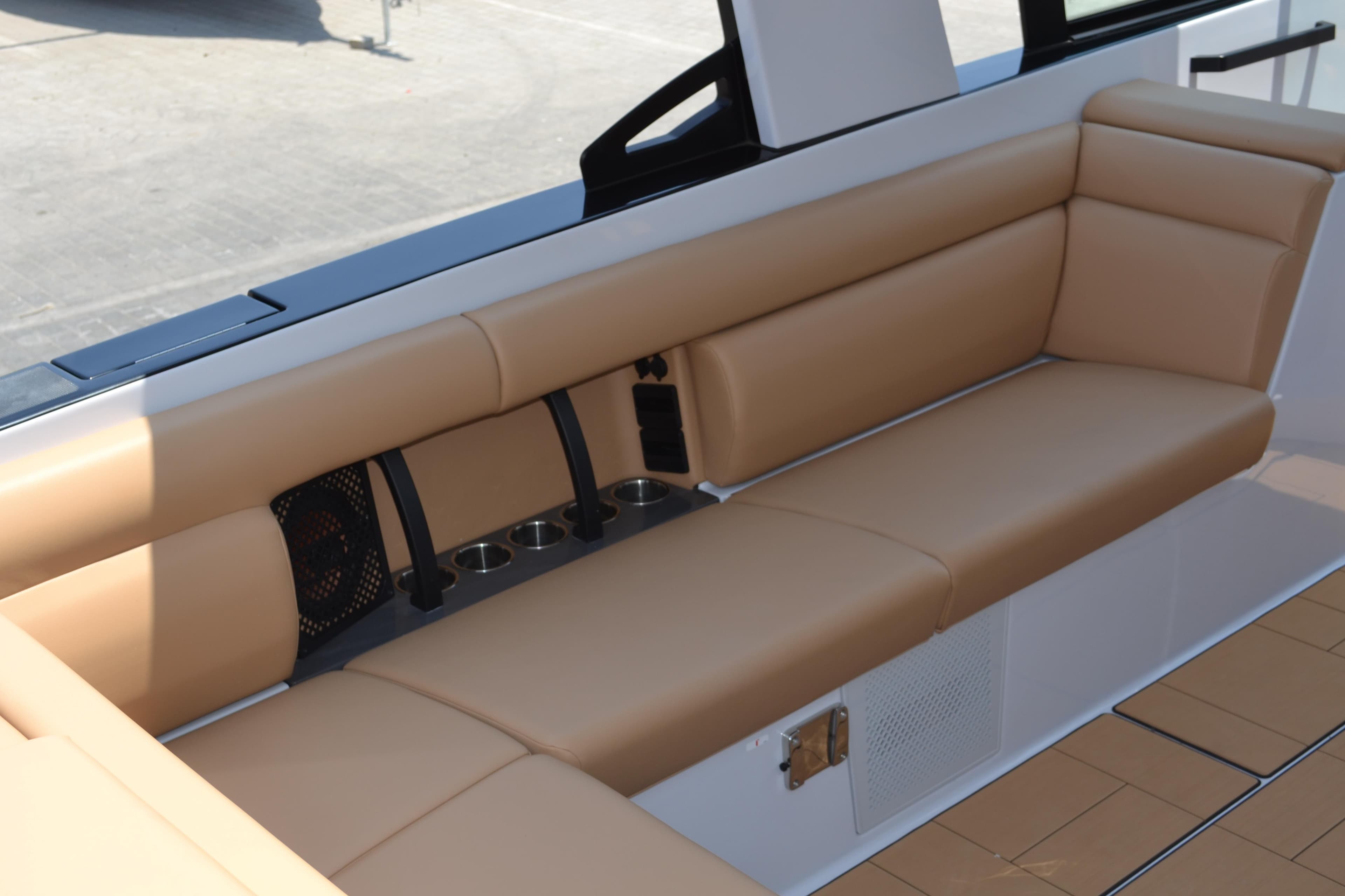 2024 Aviara AV32 OB boat interior with tan leather seating and cup holders.