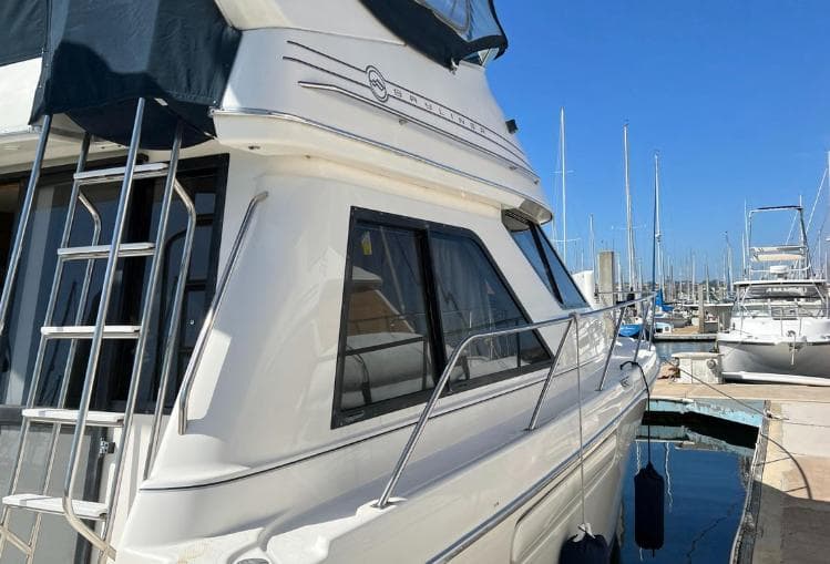 1997 Bayliner 3788 Command Bridge Motoryacht docked at marina under clear blue sky.
