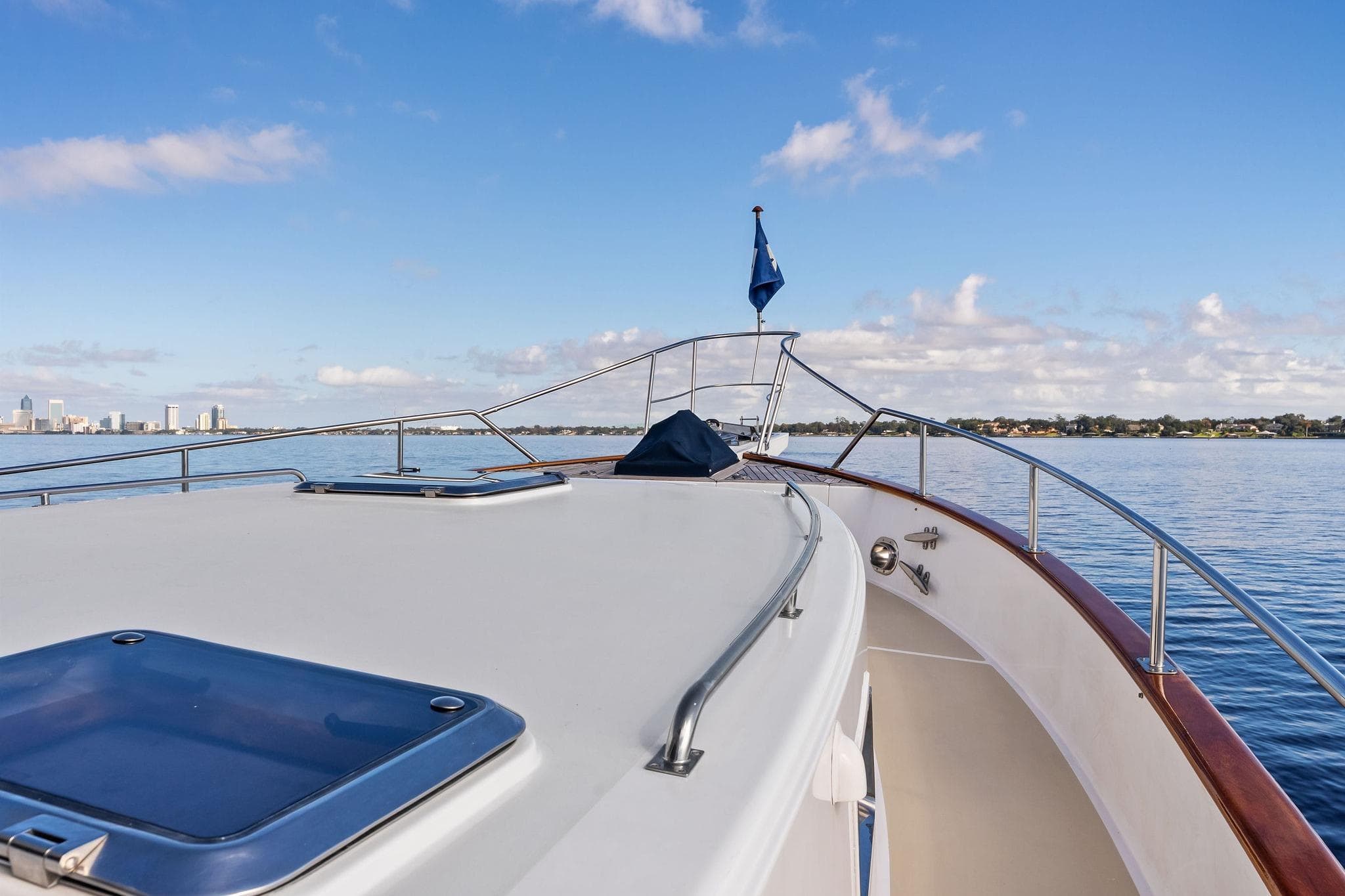 2006 Grand Banks Europa 47 yacht deck with city skyline and blue sky.