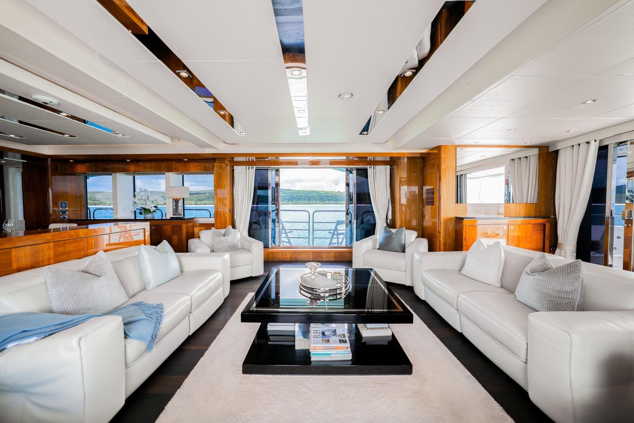 Luxurious interior of 2015 Sunseeker 115 Sport Yacht with elegant white sofas and panoramic windows.