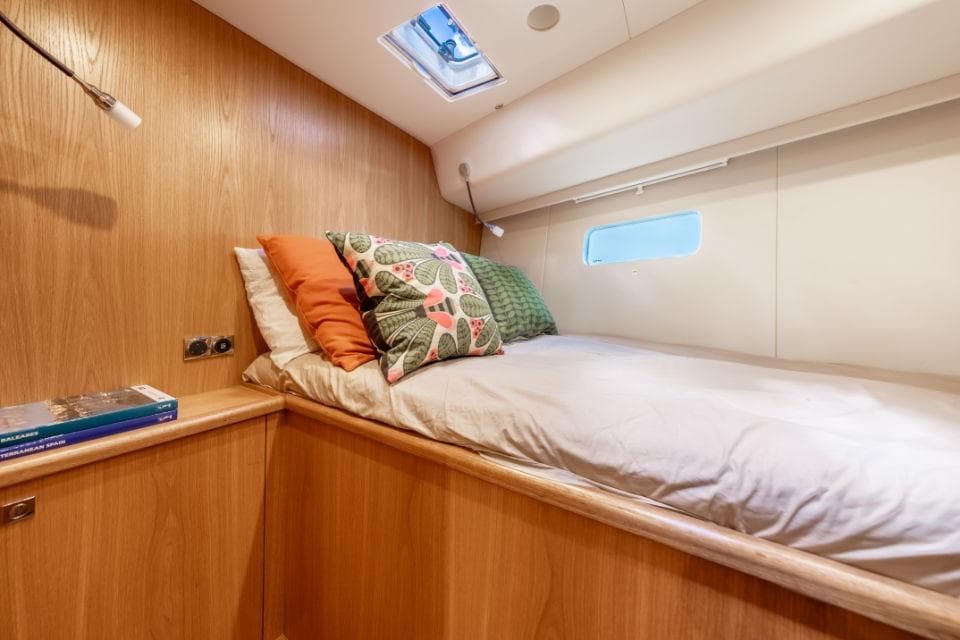 Cozy cabin interior of 2021 Discovery 58 yacht with bed and decorative pillows.