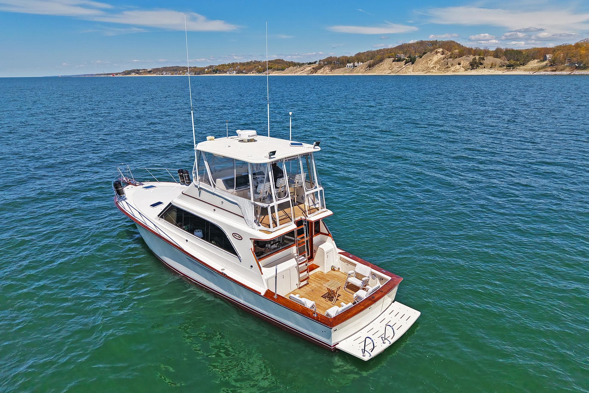 1988 Ocean Yachts 48 Super Sport cruising on clear blue waters near a scenic coastline.