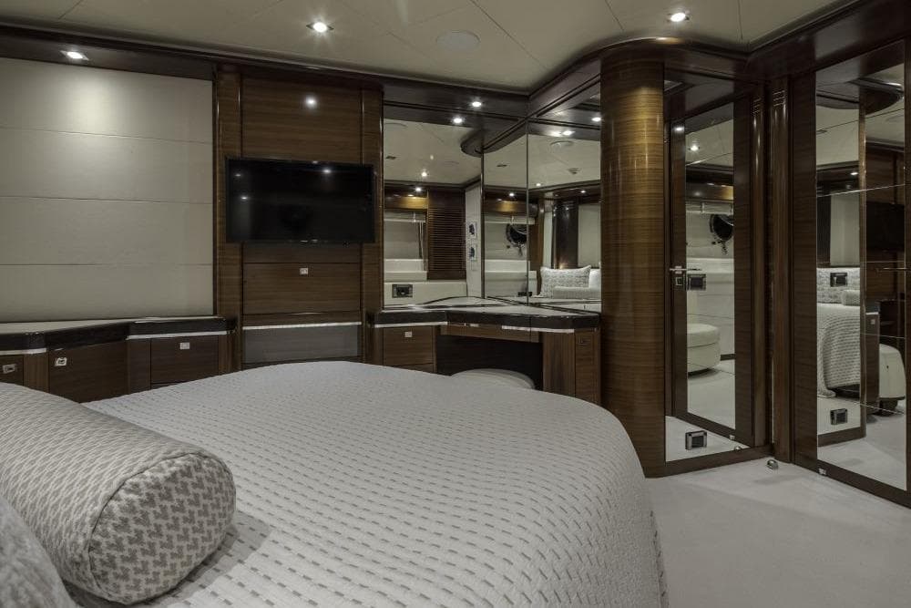 Luxurious yacht bedroom interior with modern design, featuring wood accents and a mounted TV.