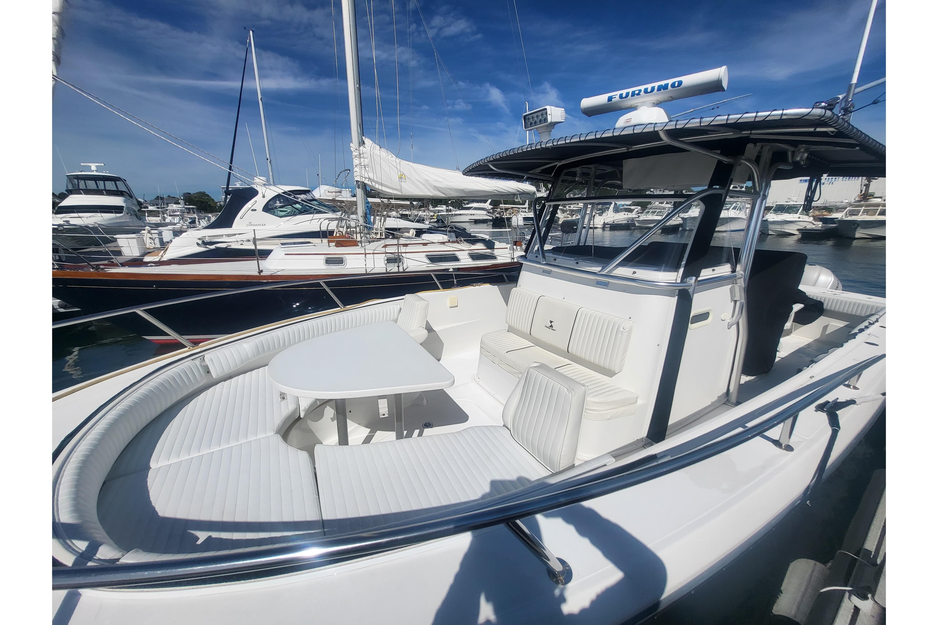 2005 Stamas 310 Tarpon boat with spacious seating and table, docked at a marina.
