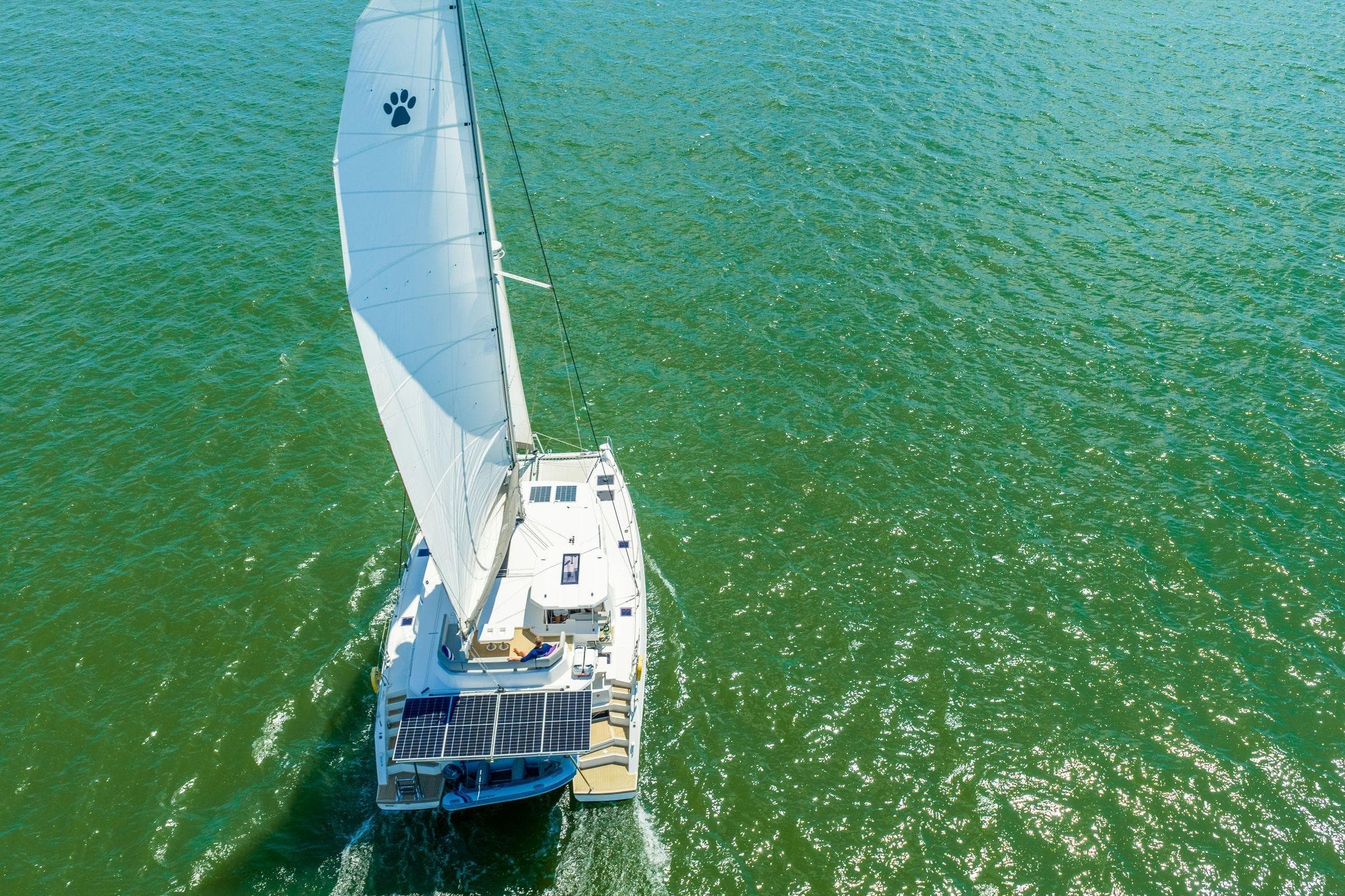 Aerial view of 2020 Leopard 45 catamaran sailing on open water.