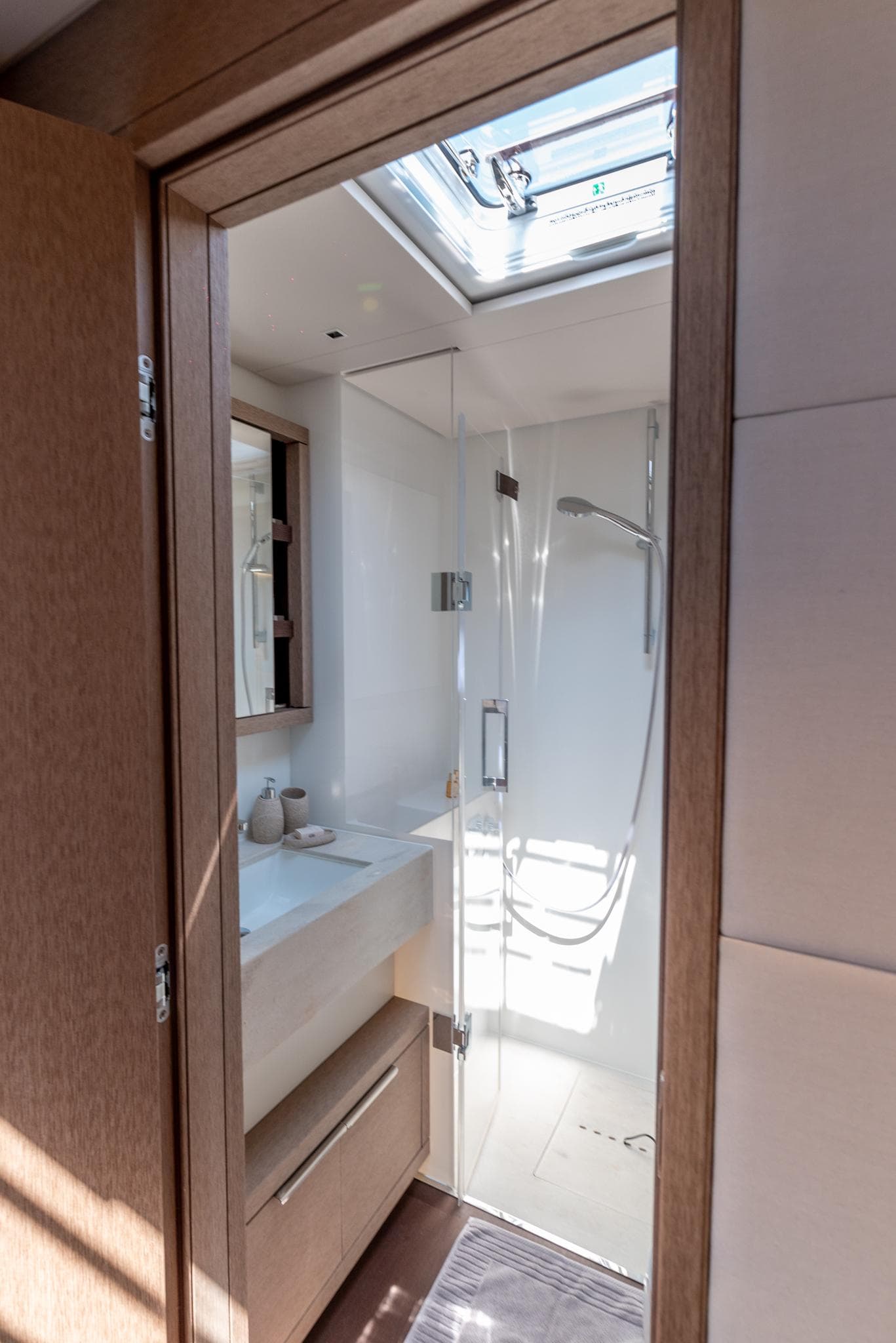 2024 Lagoon SIXTY 5 yacht bathroom with skylight, modern shower, and sleek design.