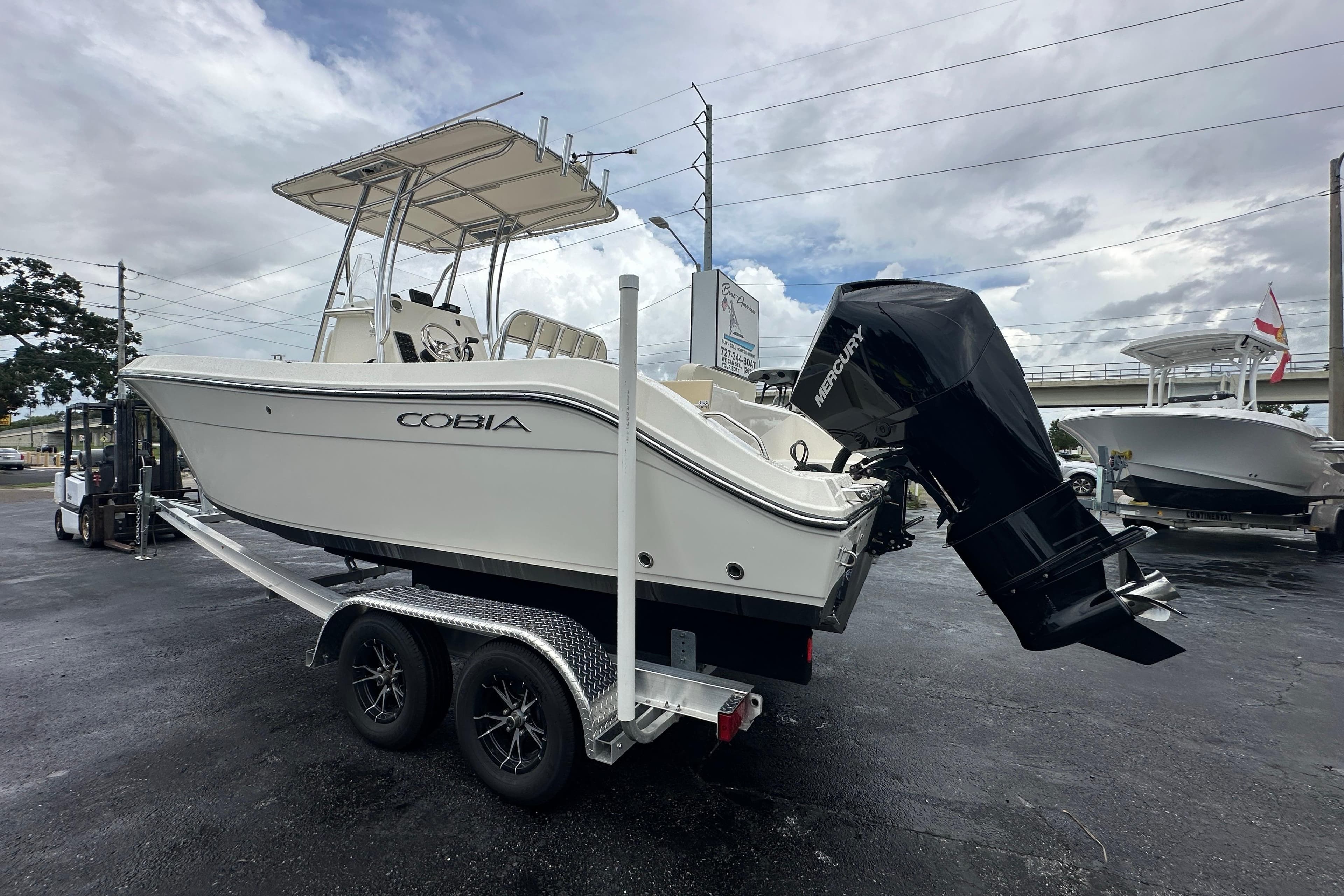 2022 Cobia 237 Center Console boat on trailer, featuring Mercury outboard motor.